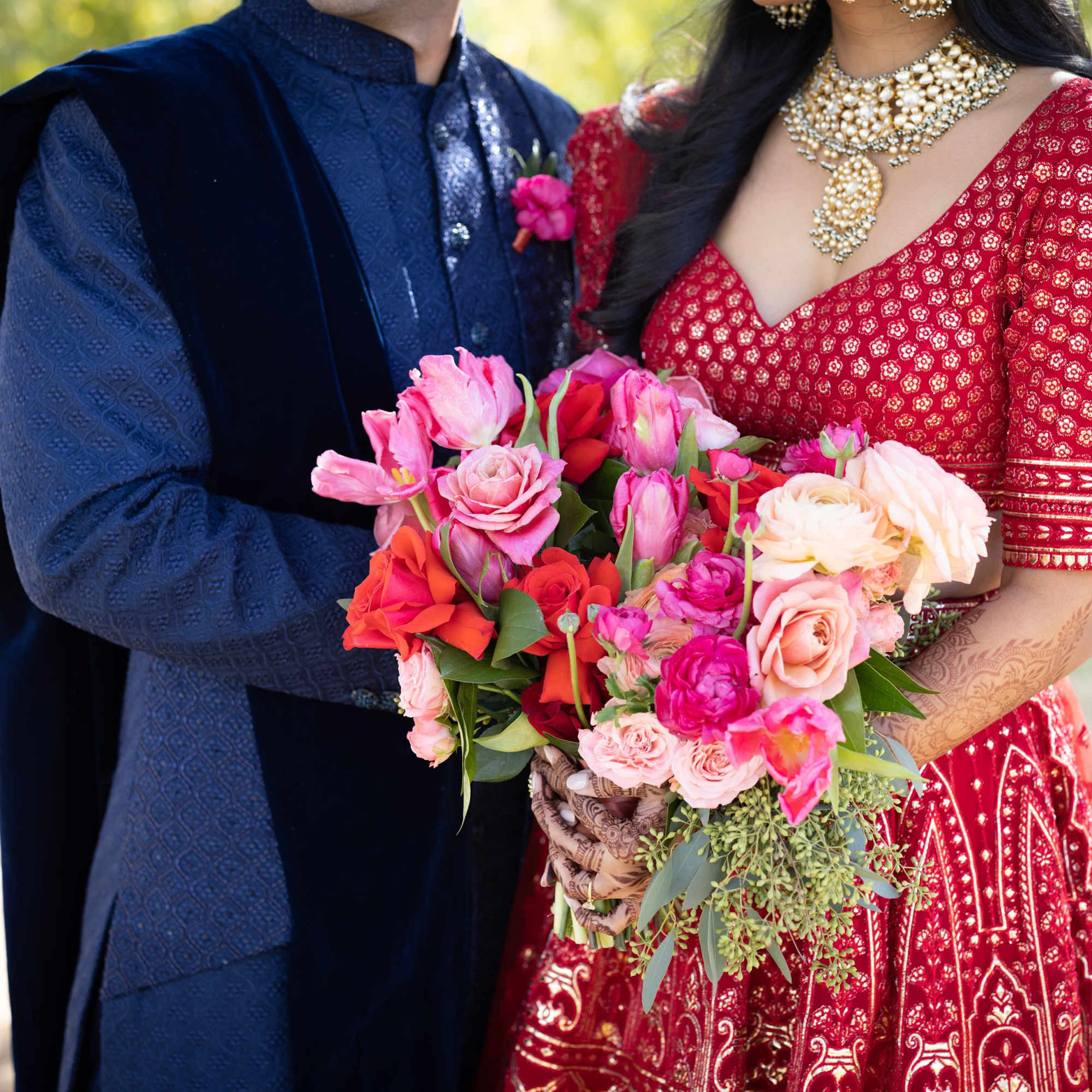 Couple holding colorful bouquets with pink and red flowers