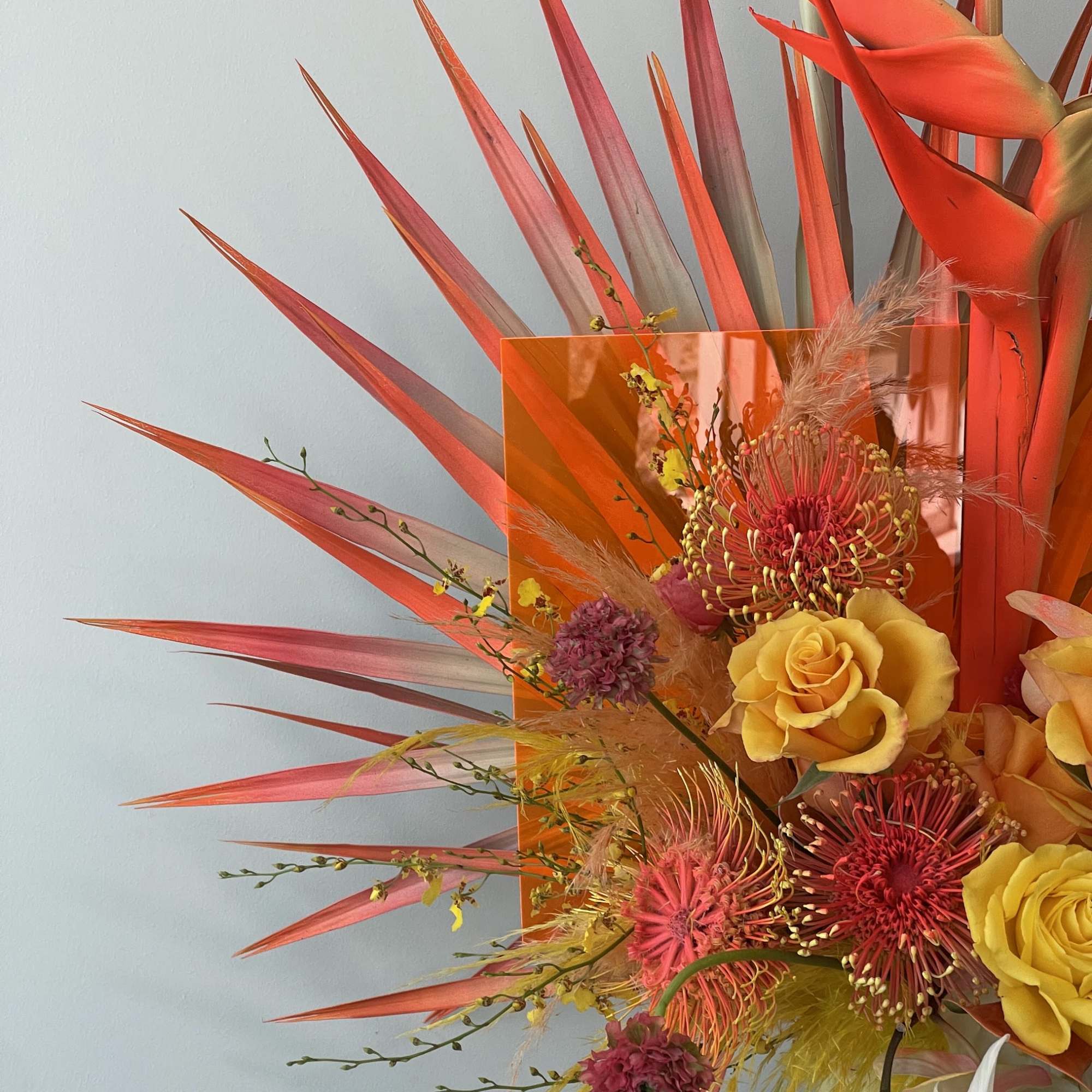 Bright tropical bouquet with yellow roses and pink pincushion blooms