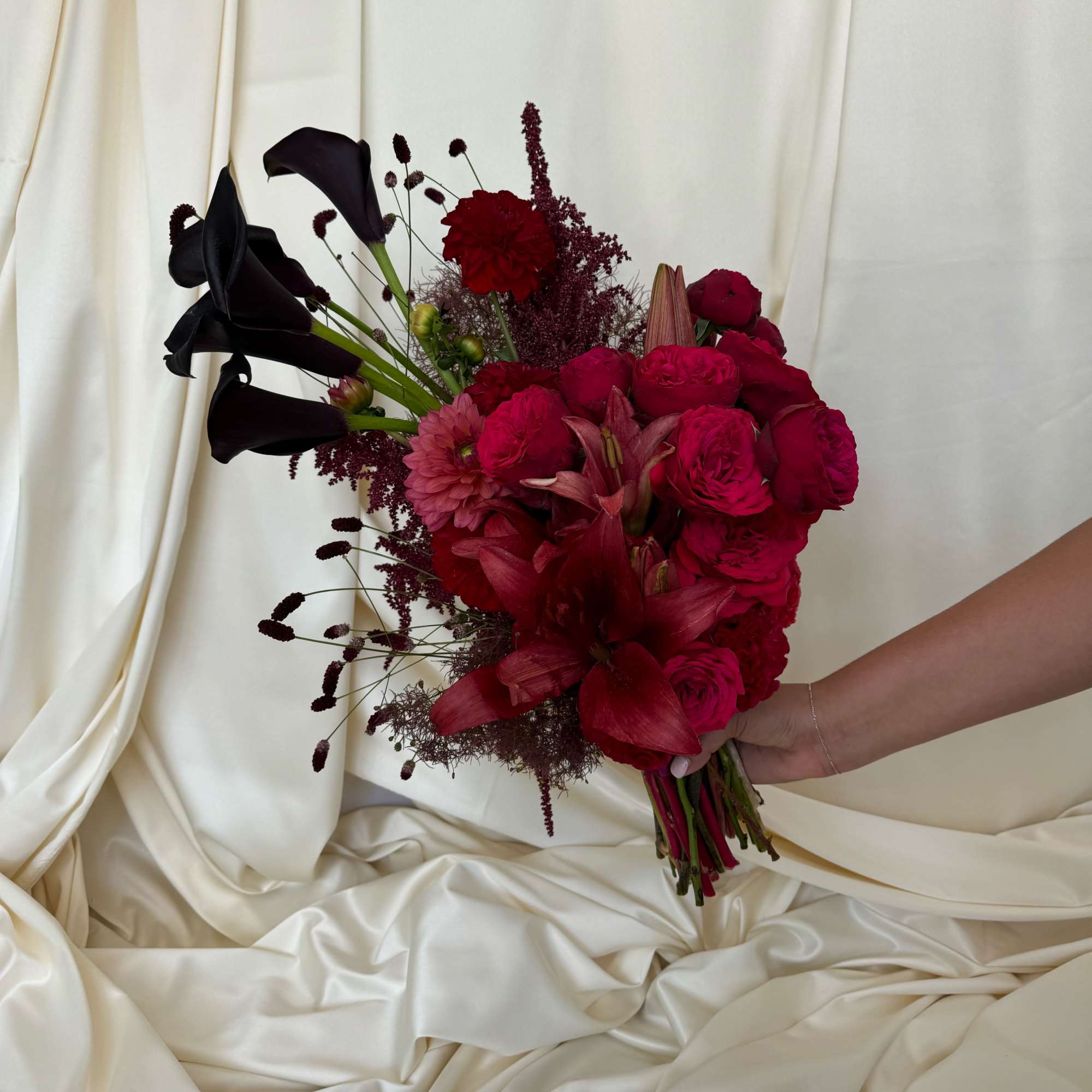 Bouquet of deep red flowers with black calla lilies