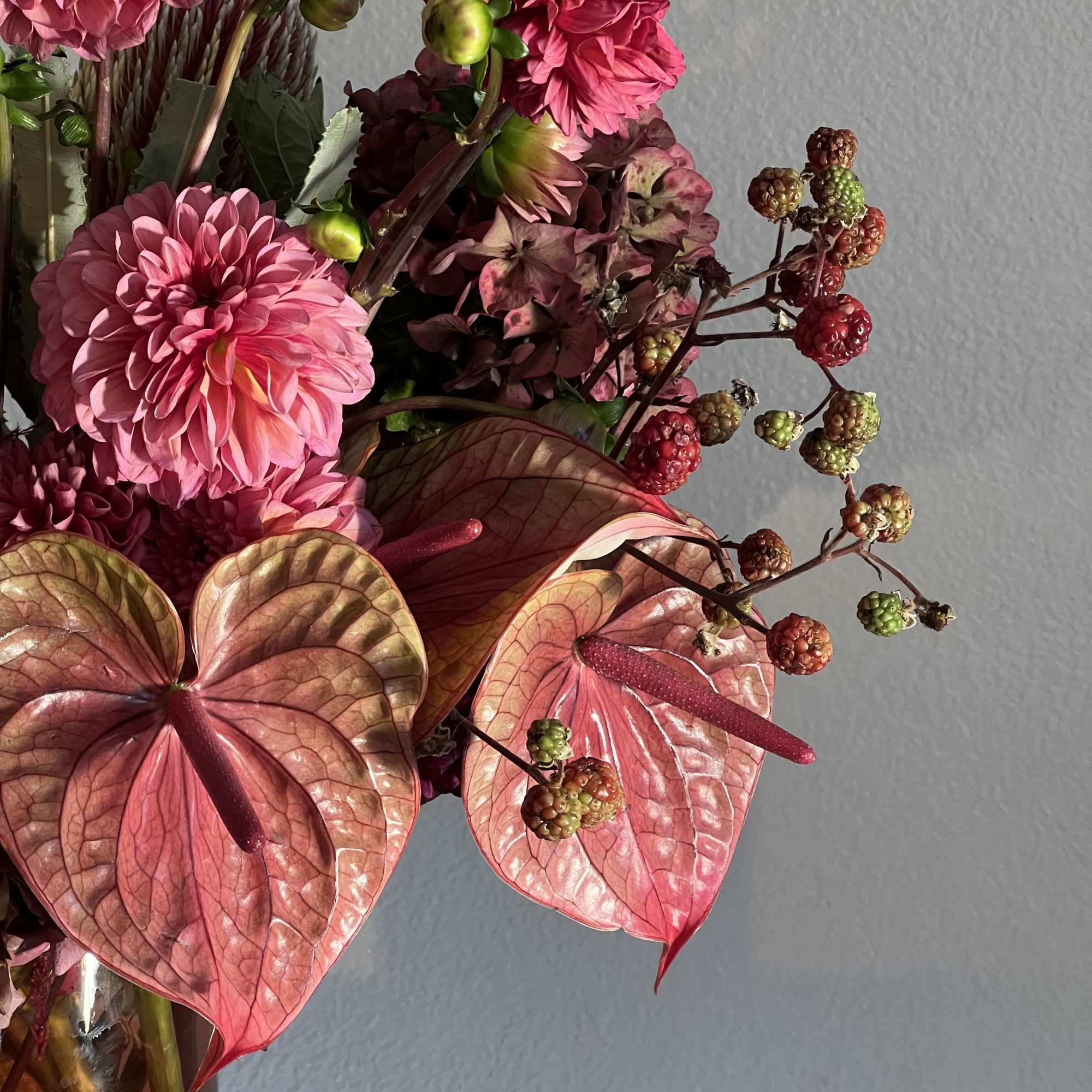 Pink floral arrangement with anthuriums and dahlias in a vase