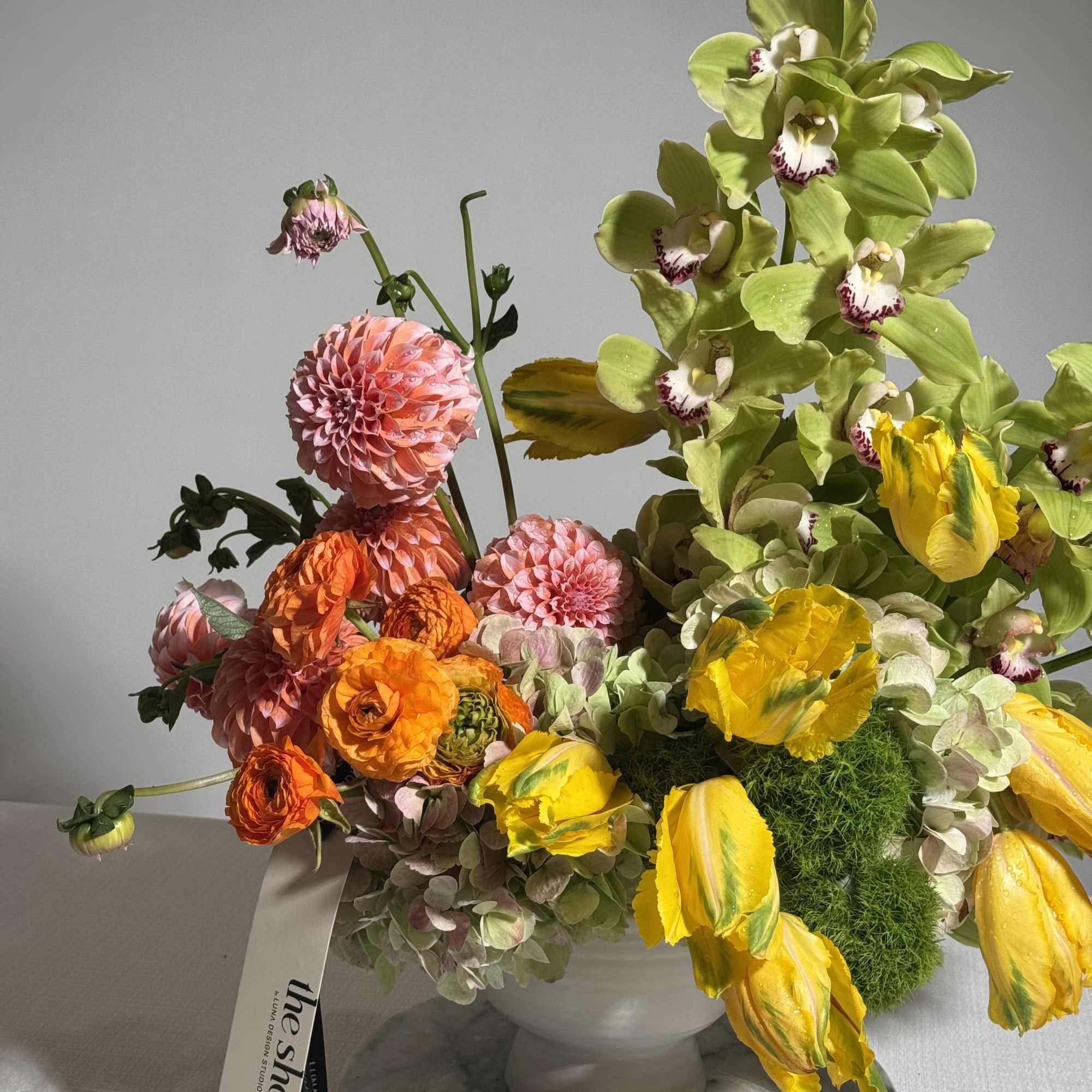 Colorful floral arrangement in a white pedestal vase