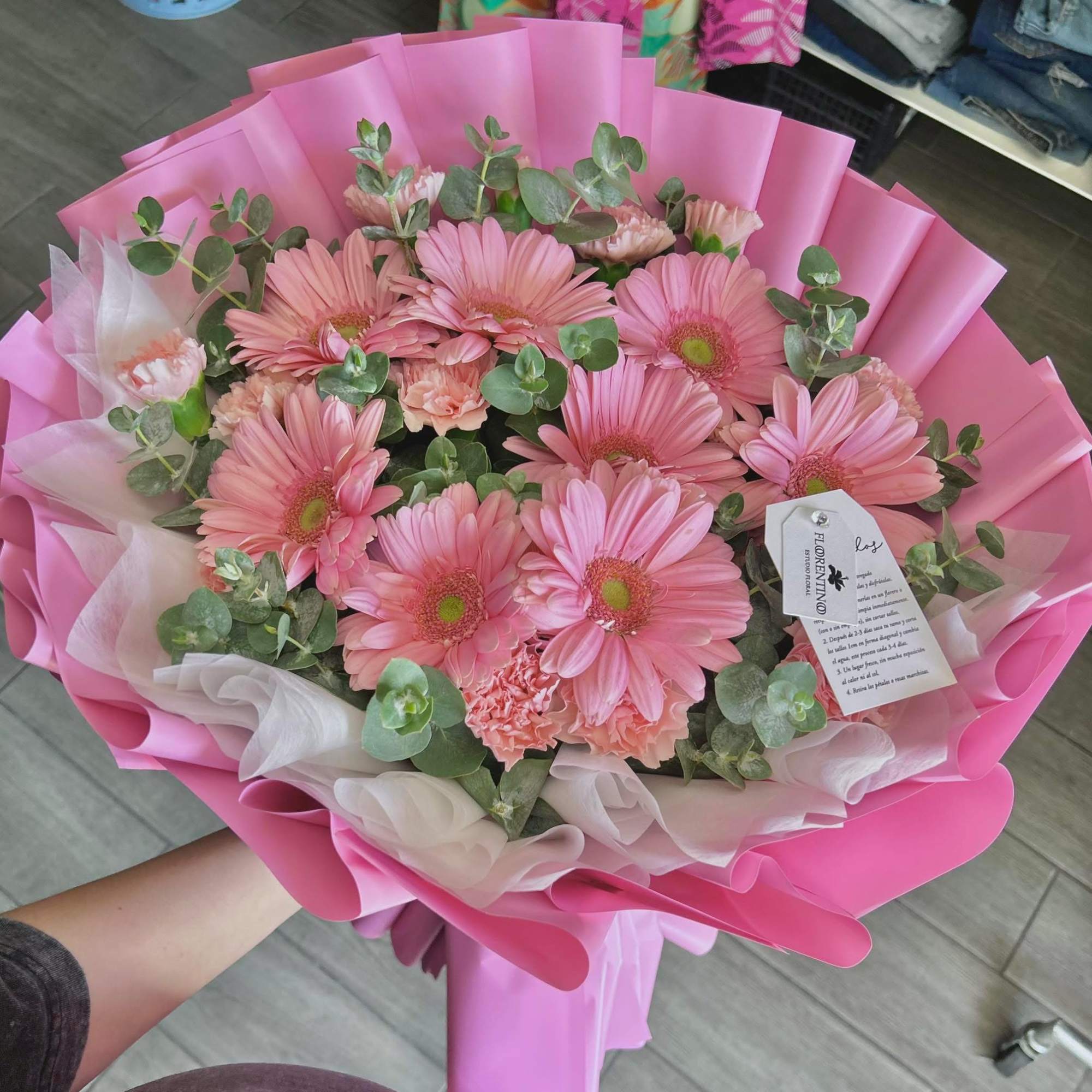Pink gerbera daisy bouquet wrapped in pink paper with white tissue