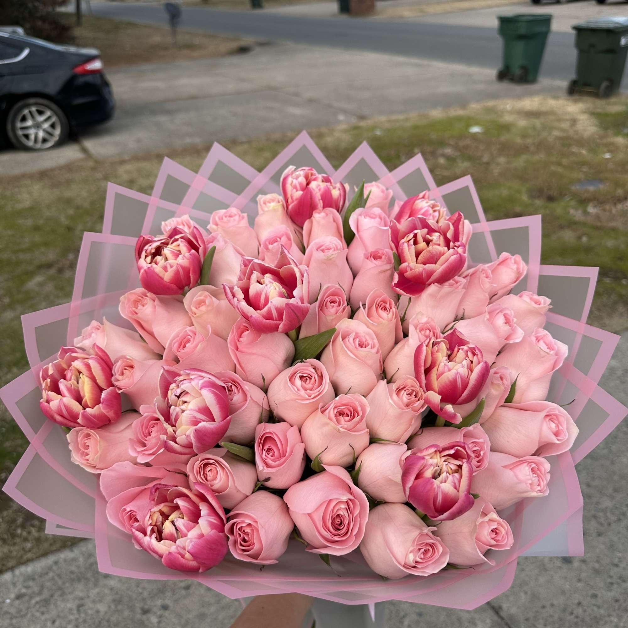 Bouquet of pink roses and pink tulips wrapped in pink paper