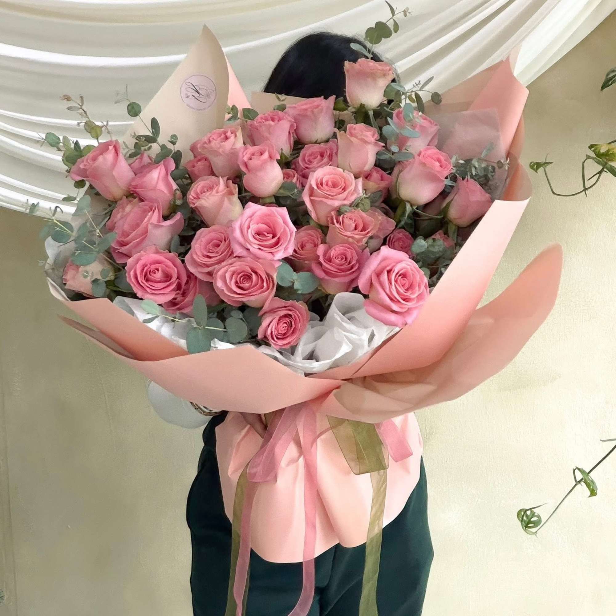 Large bouquet of pink roses wrapped in blush paper