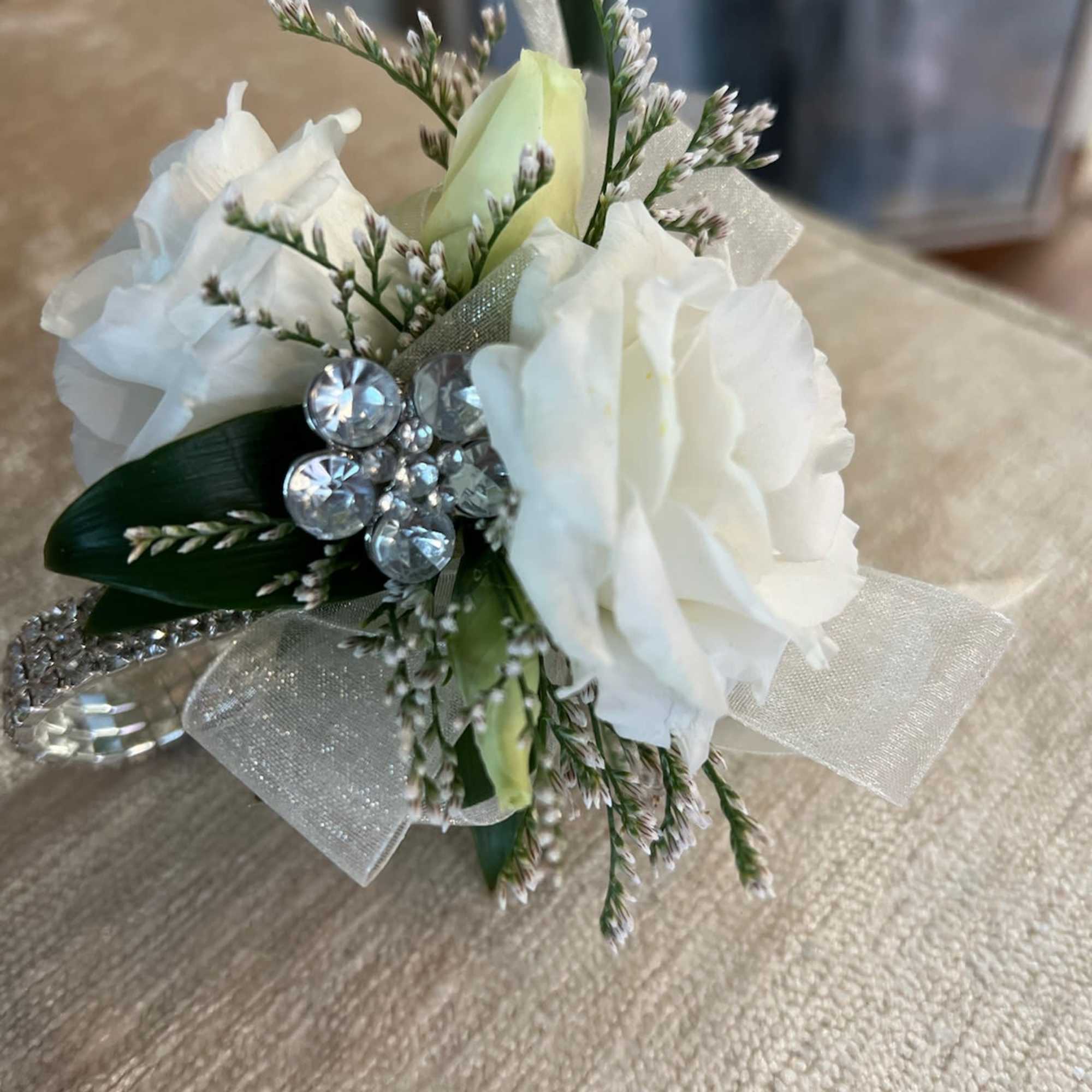 Small white rose corsage with rhinestone accents and sheer ribbon