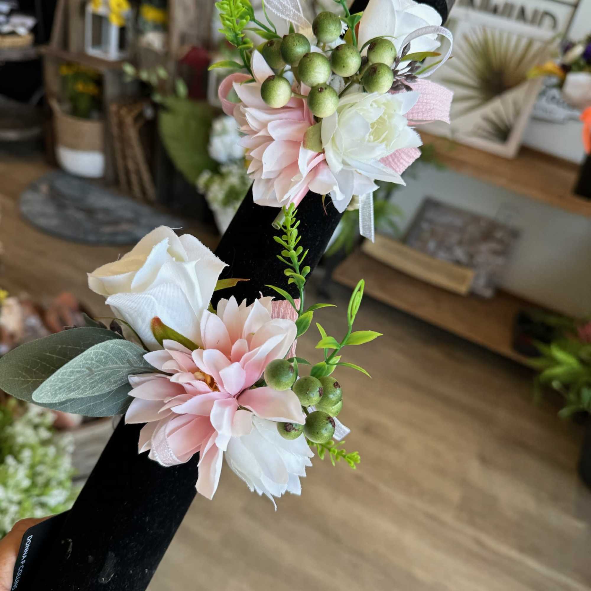 Floral corsage with pink and white blooms on a black wristband