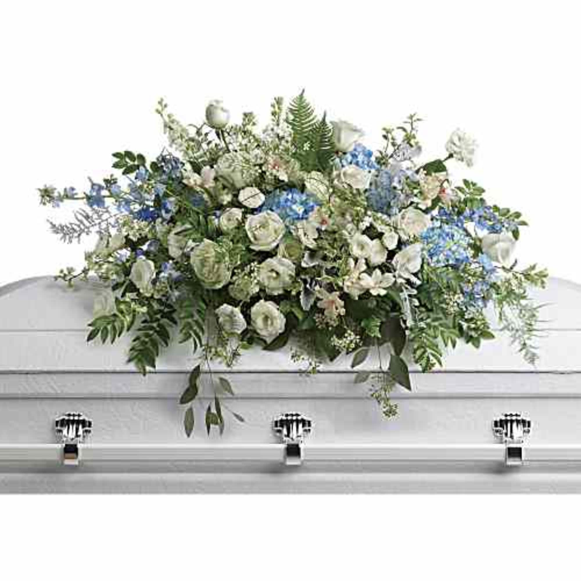 White and blue floral casket spray with greenery on a white casket