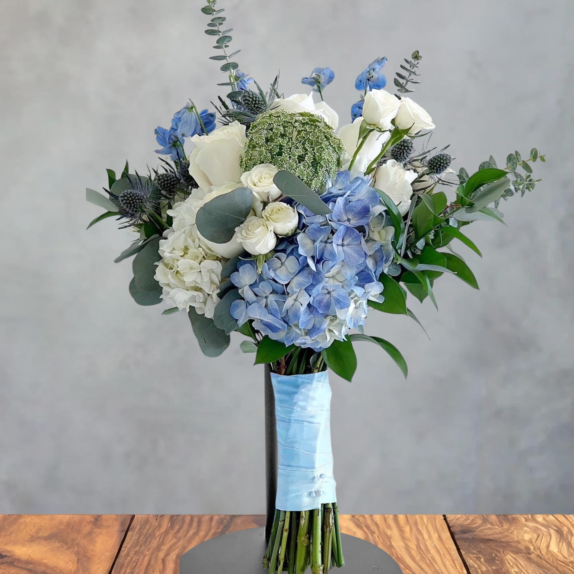 Blue and white bouquet with hydrangeas and roses on a stand
