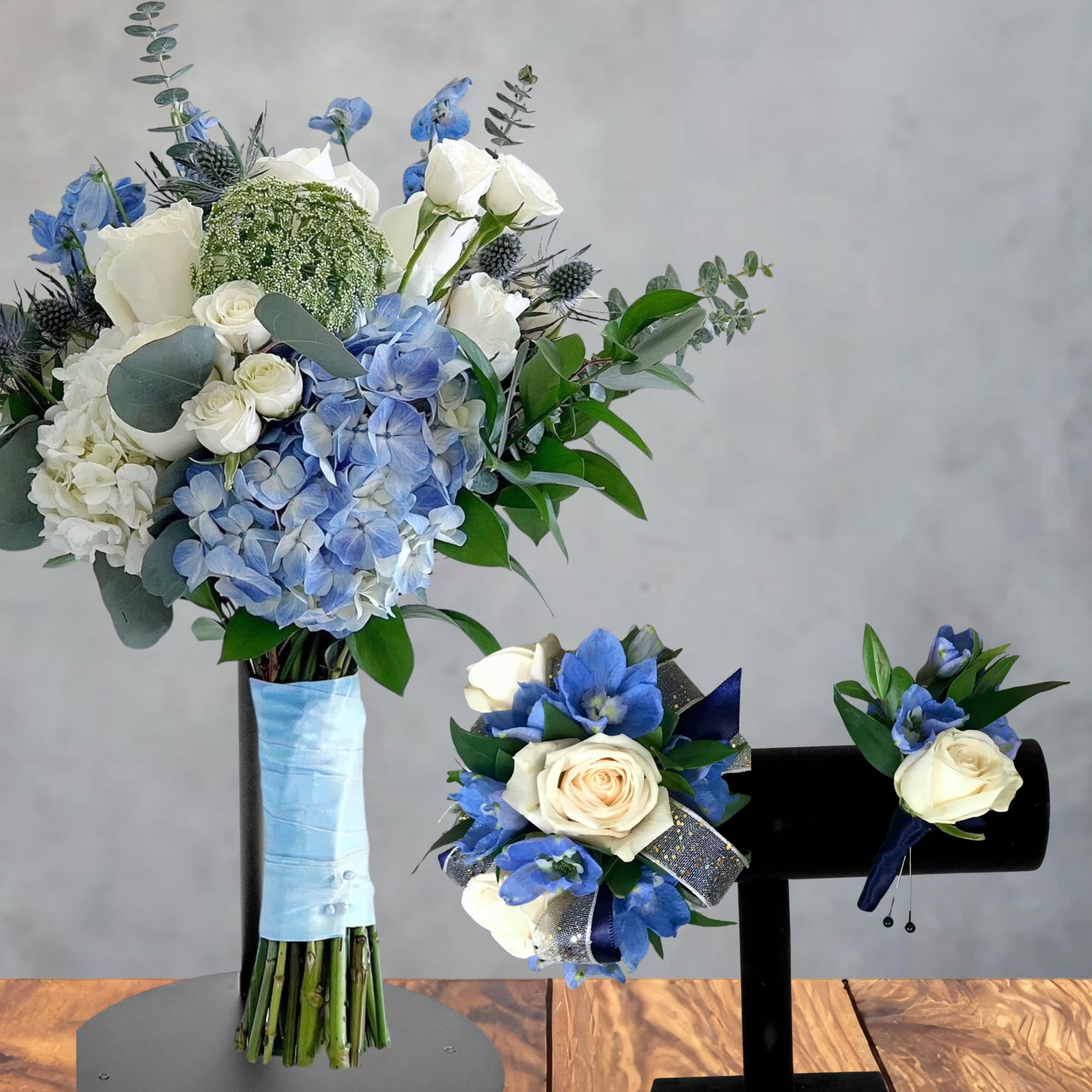 Blue and white floral bouquet with roses and hydrangeas, plus matching boutonnieres