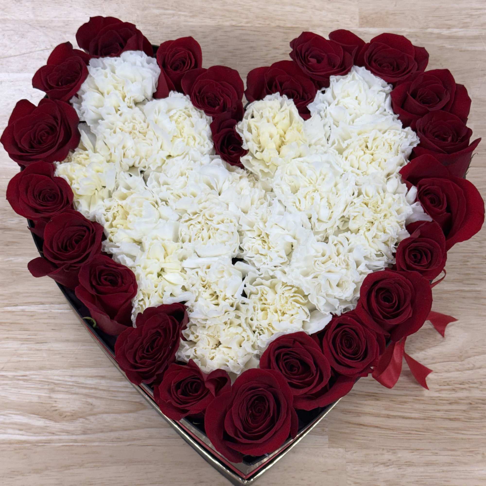 Heart-shaped box of red roses and white carnations
