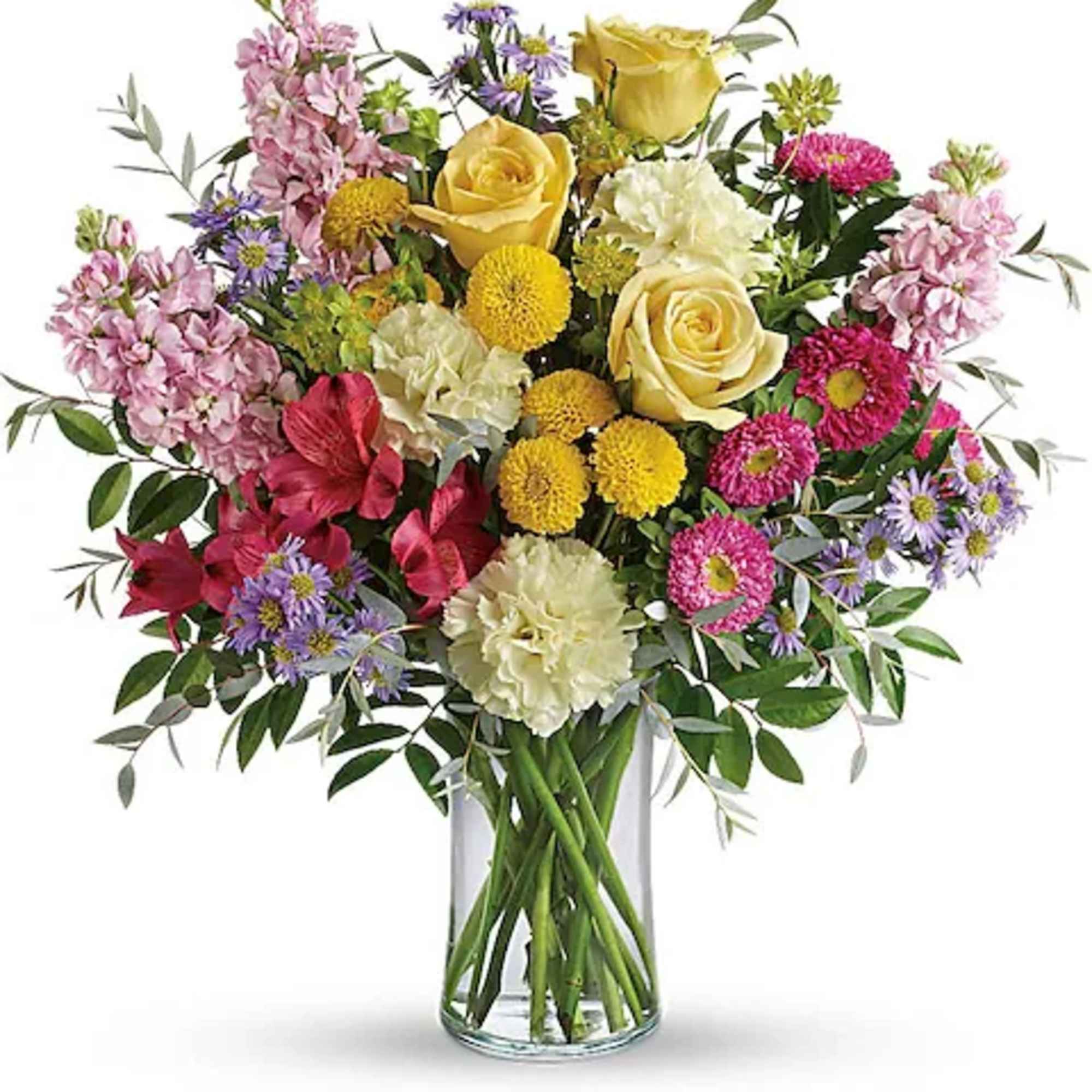 Mixed bouquet of yellow roses, pink flowers, and purple daisies in a glass vase