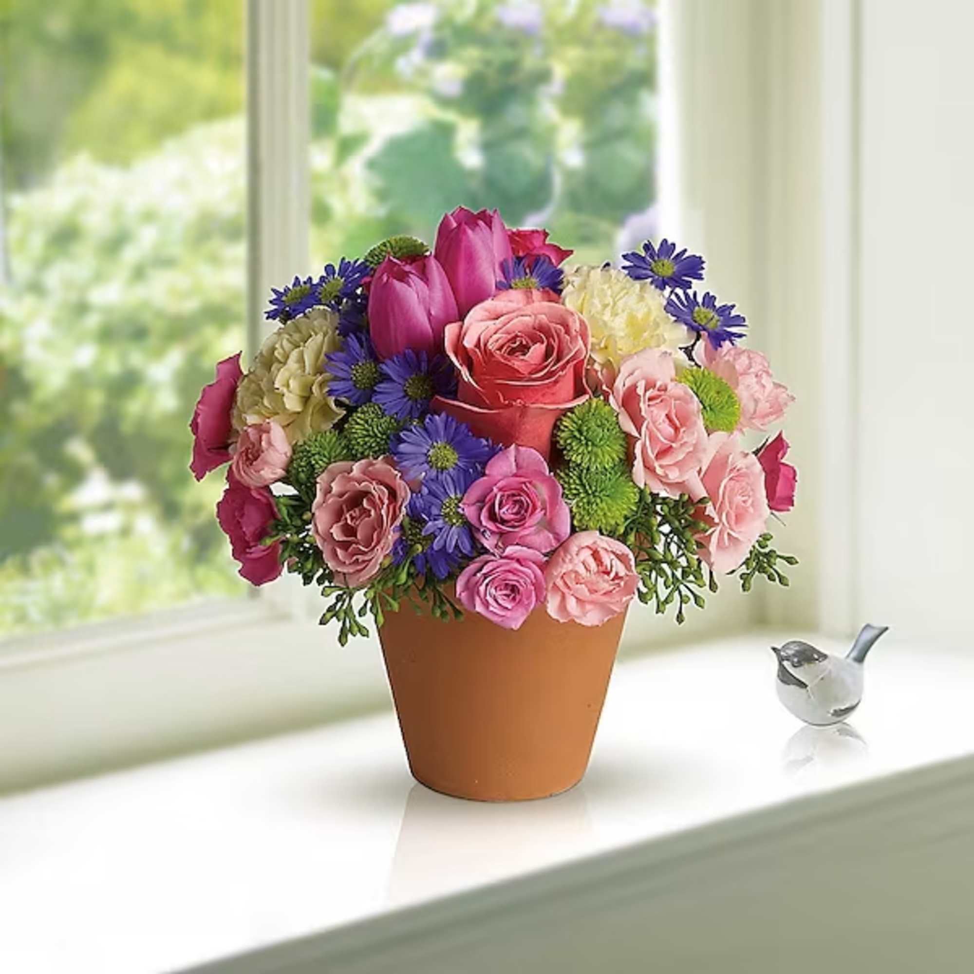 Mixed pink and purple flower arrangement in a terracotta pot