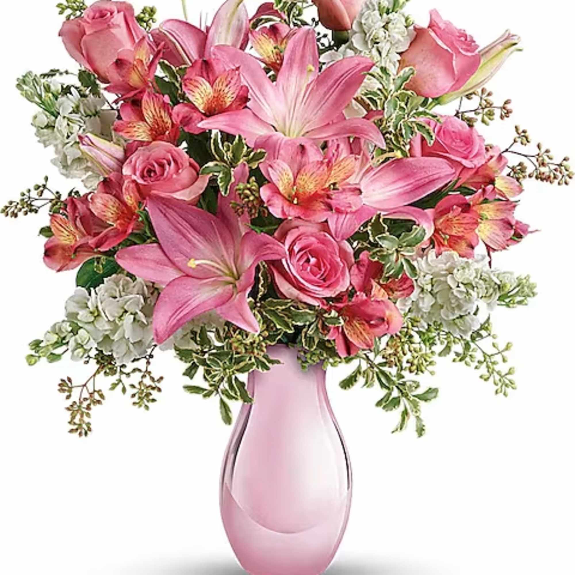 Pink roses and lilies arranged in a pink glass vase