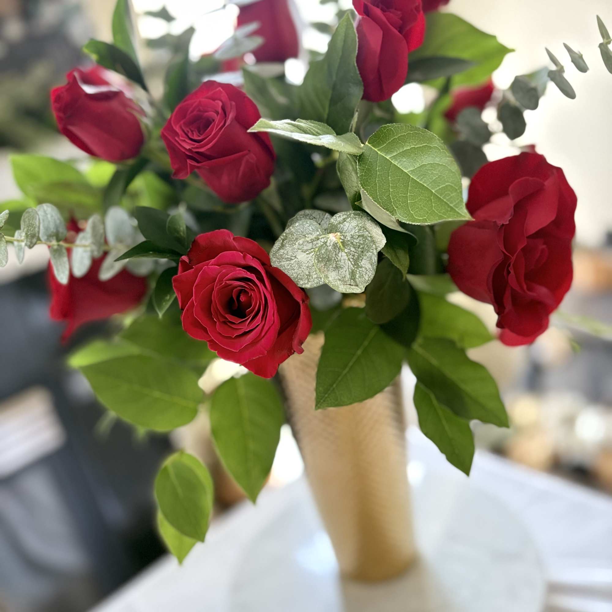 Bouquet of red roses in a tan wrap with greenery