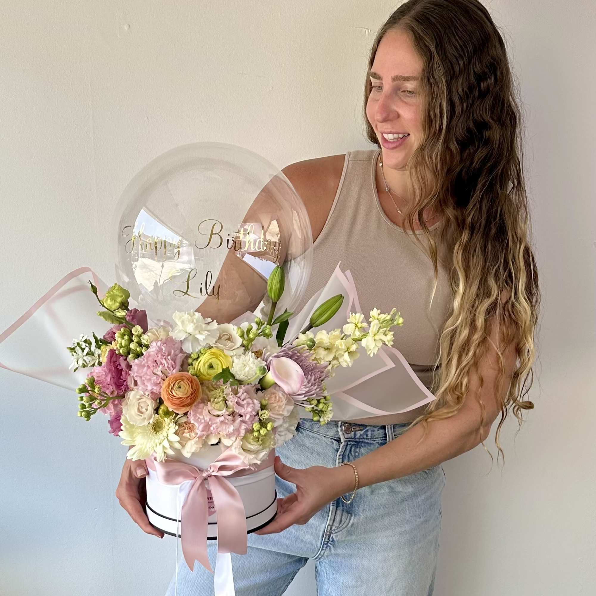Birthday flower arrangement with a clear balloon and pink ribbon in a white box