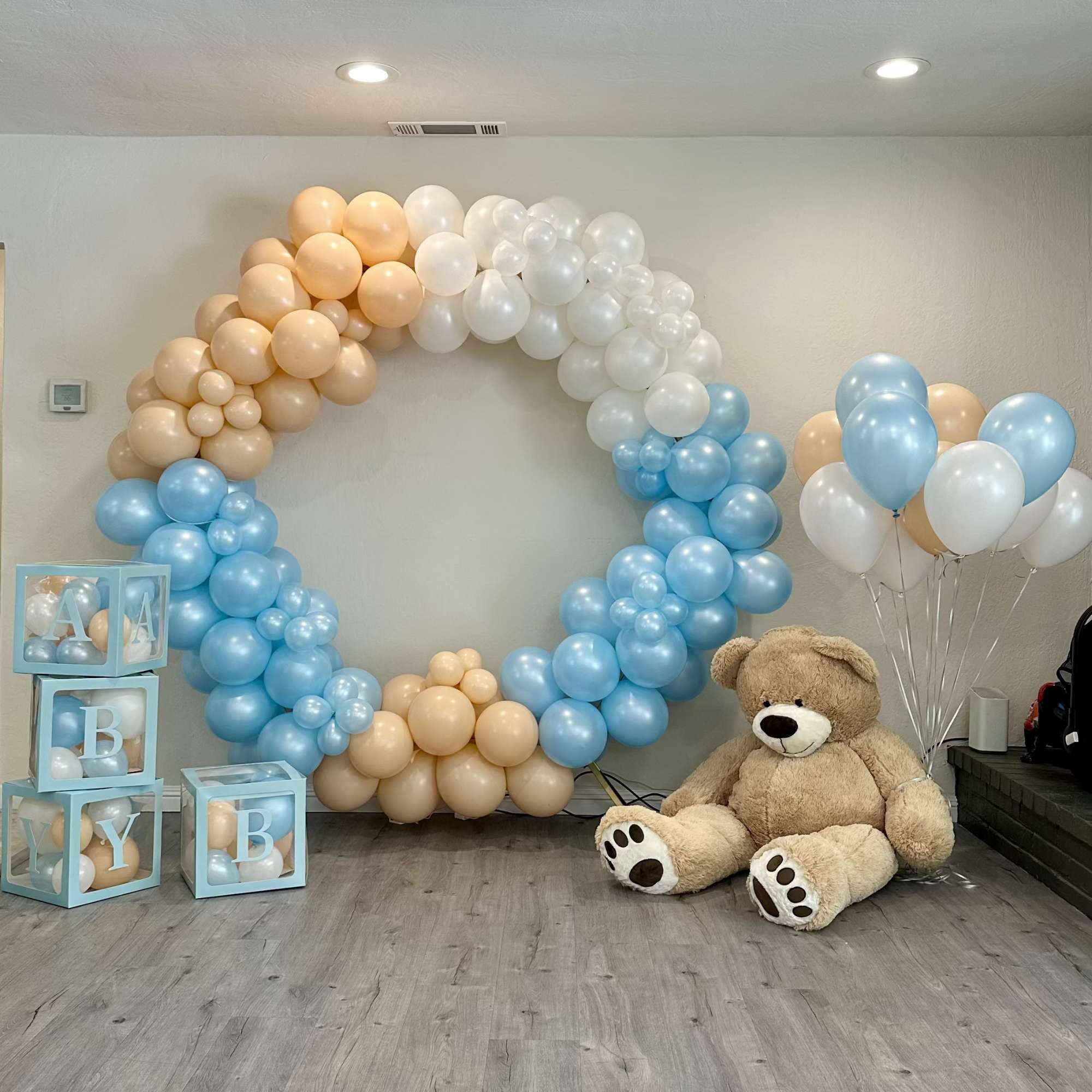 Pastel balloon arch with teddy bear, balloon bouquet, and letter blocks