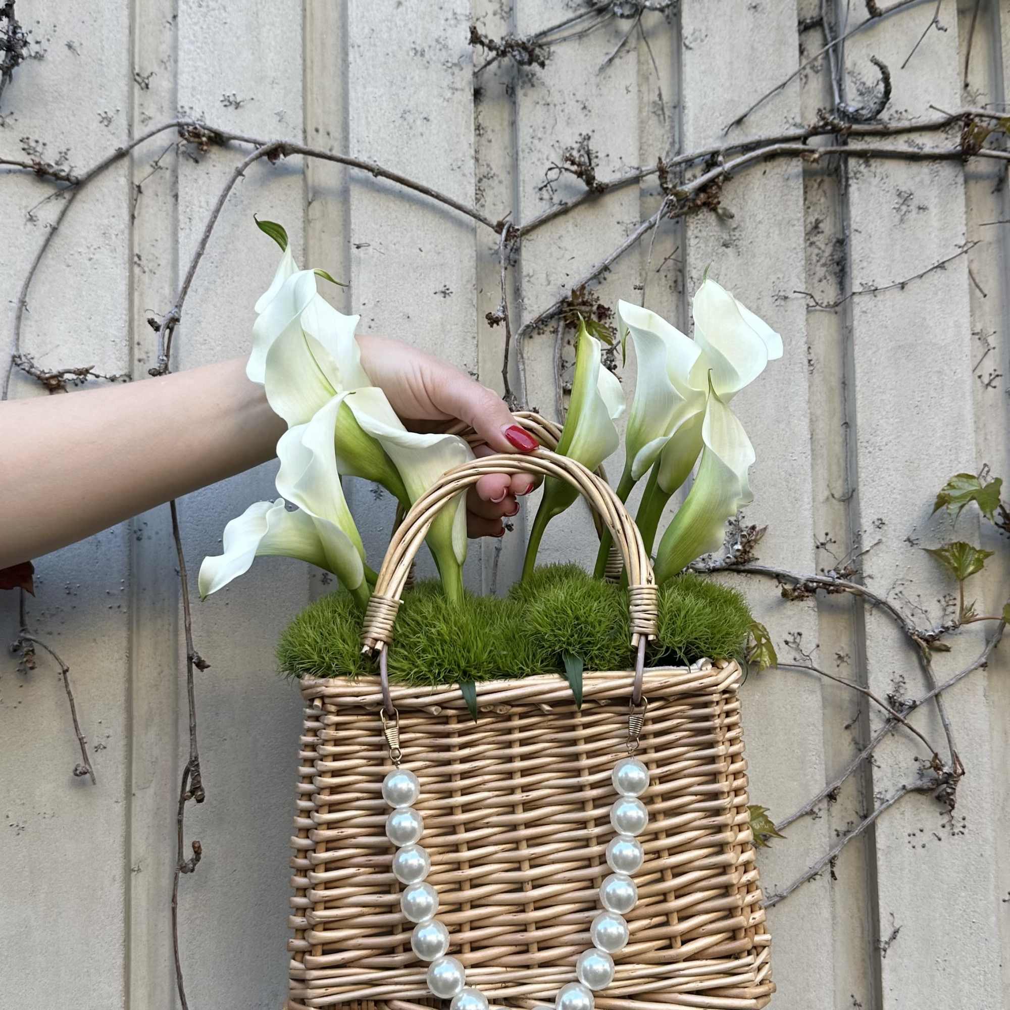 Wicker basket with white calla lilies and pearl handles