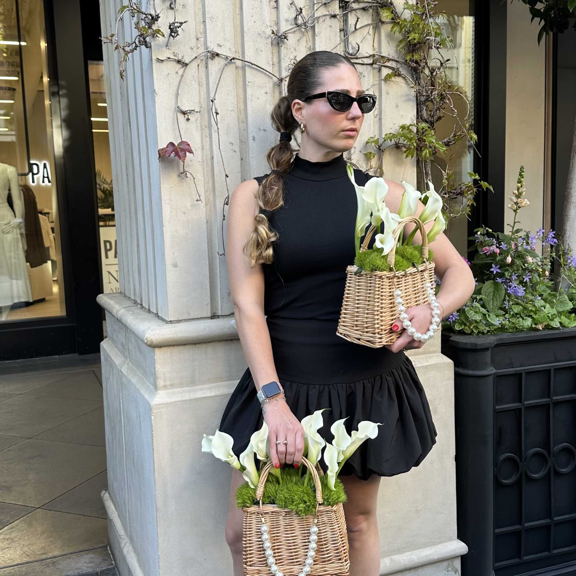 Woman holding two wicker baskets with white calla lilies
