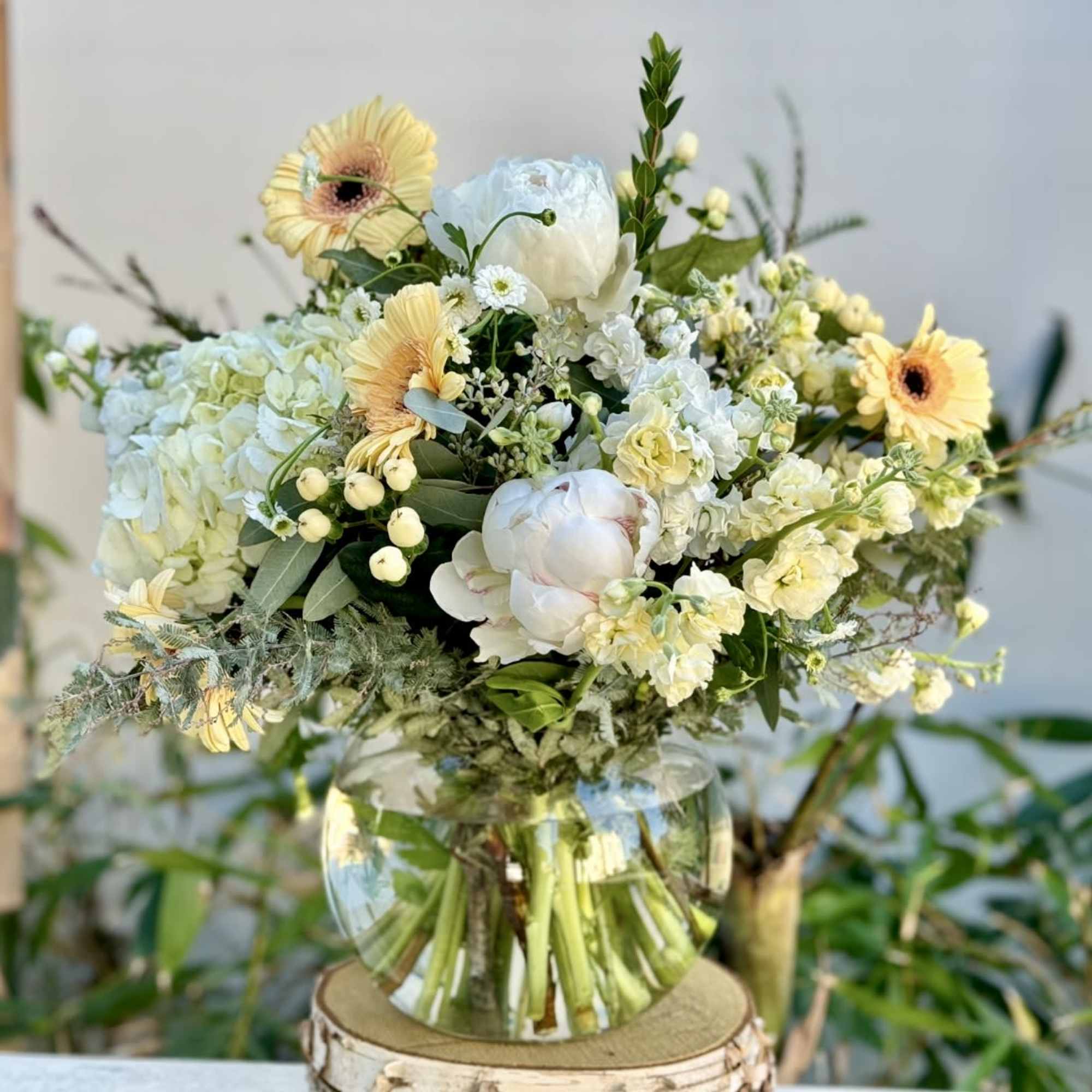 Bouquet of pale yellow and white flowers in a clear glass vase