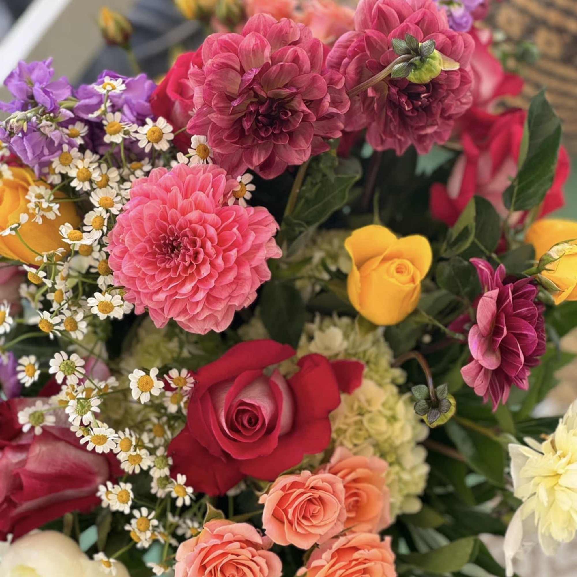 Colorful bouquet with pink dahlias, roses, and small white daisies
