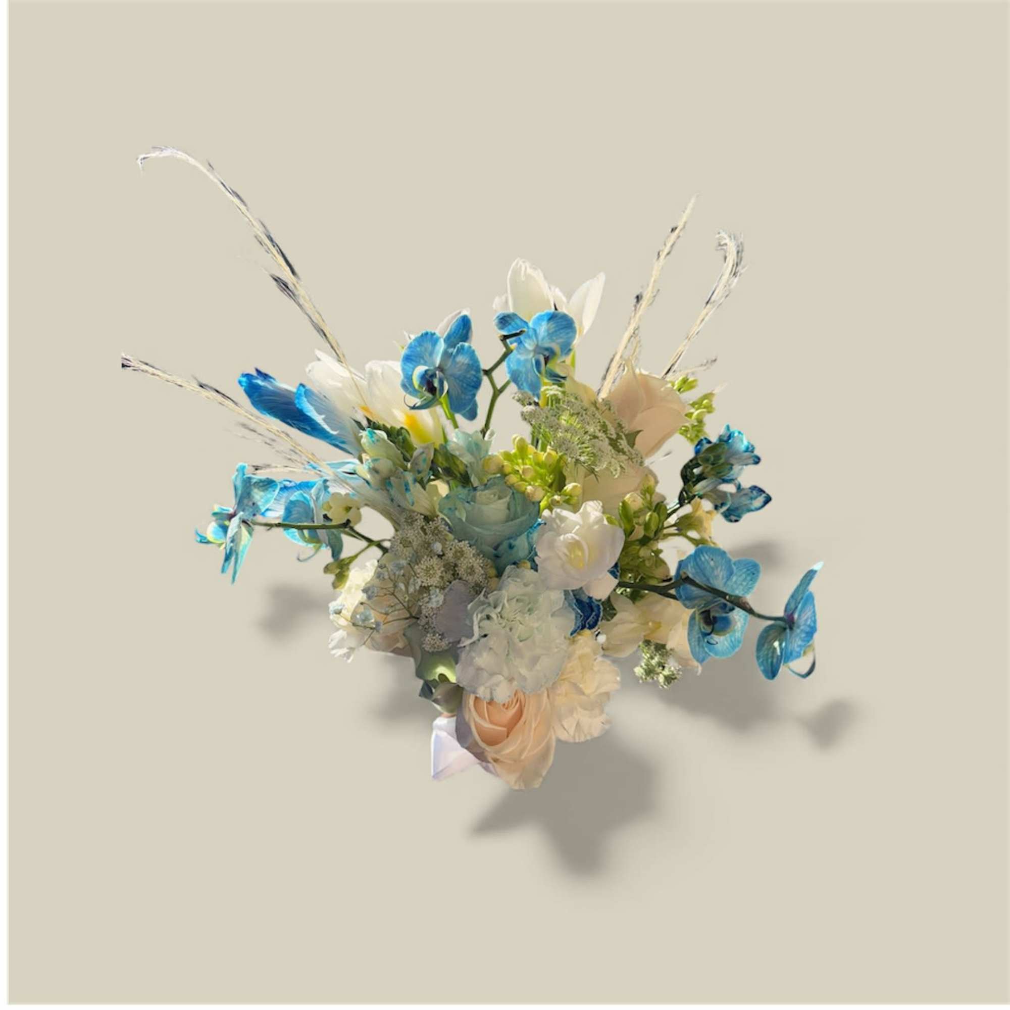 Blue and white floral bouquet with peach roses and tall decorative grasses