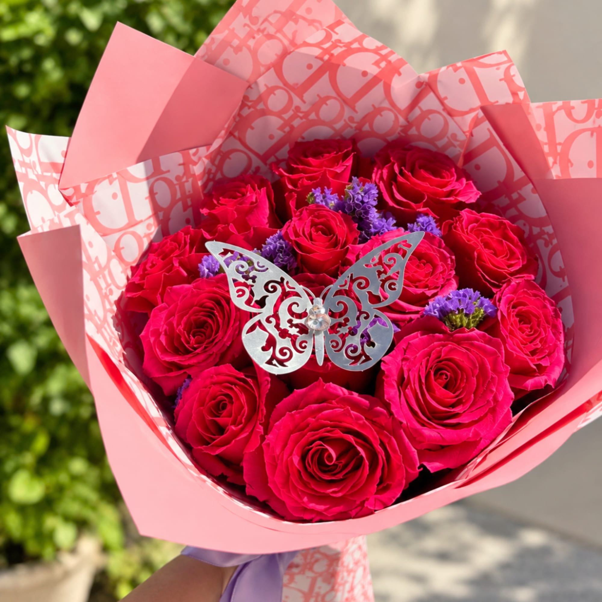 Pink rose bouquet with purple accents and a butterfly decoration
