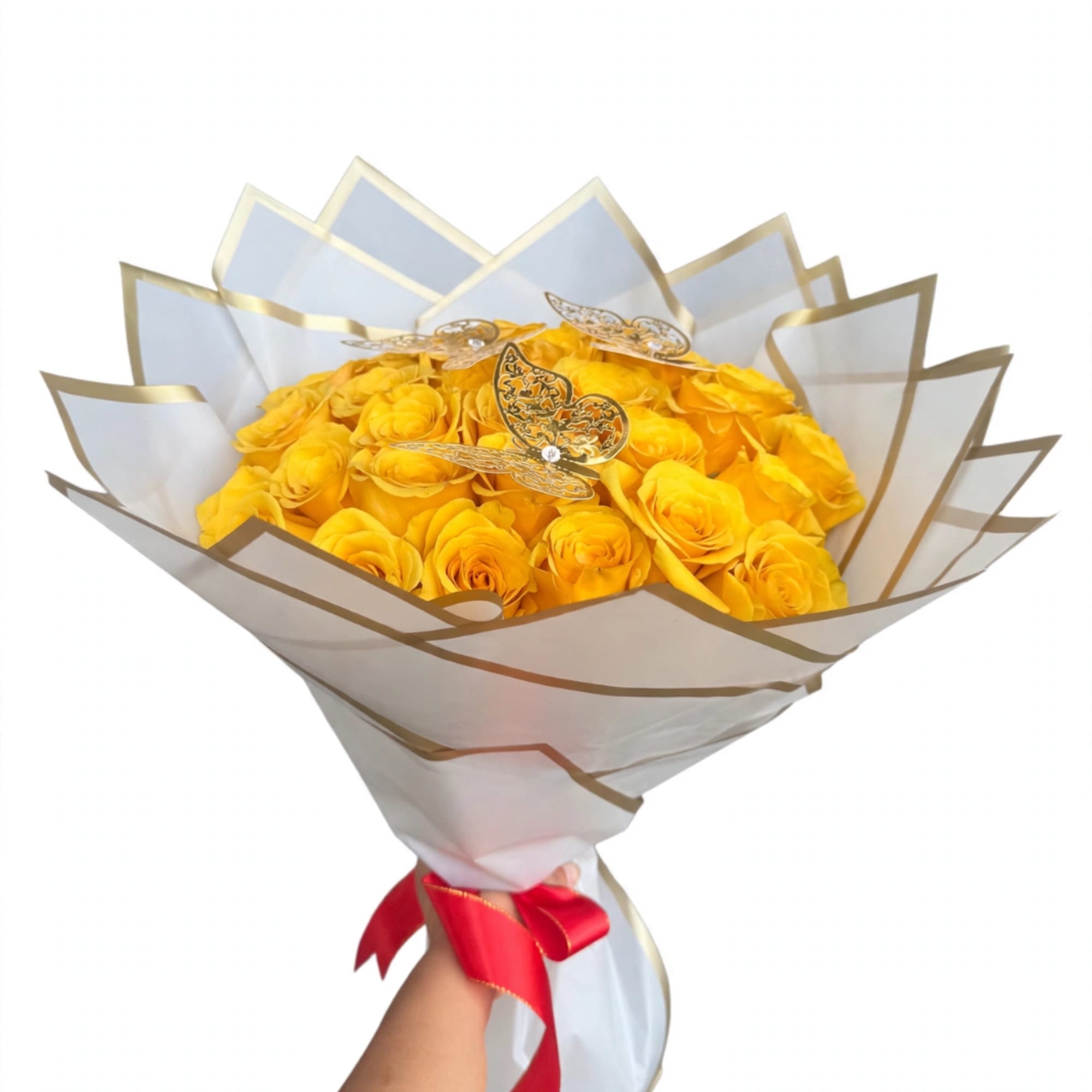 Bouquet of yellow roses wrapped in white paper with gold trim and a red ribbon