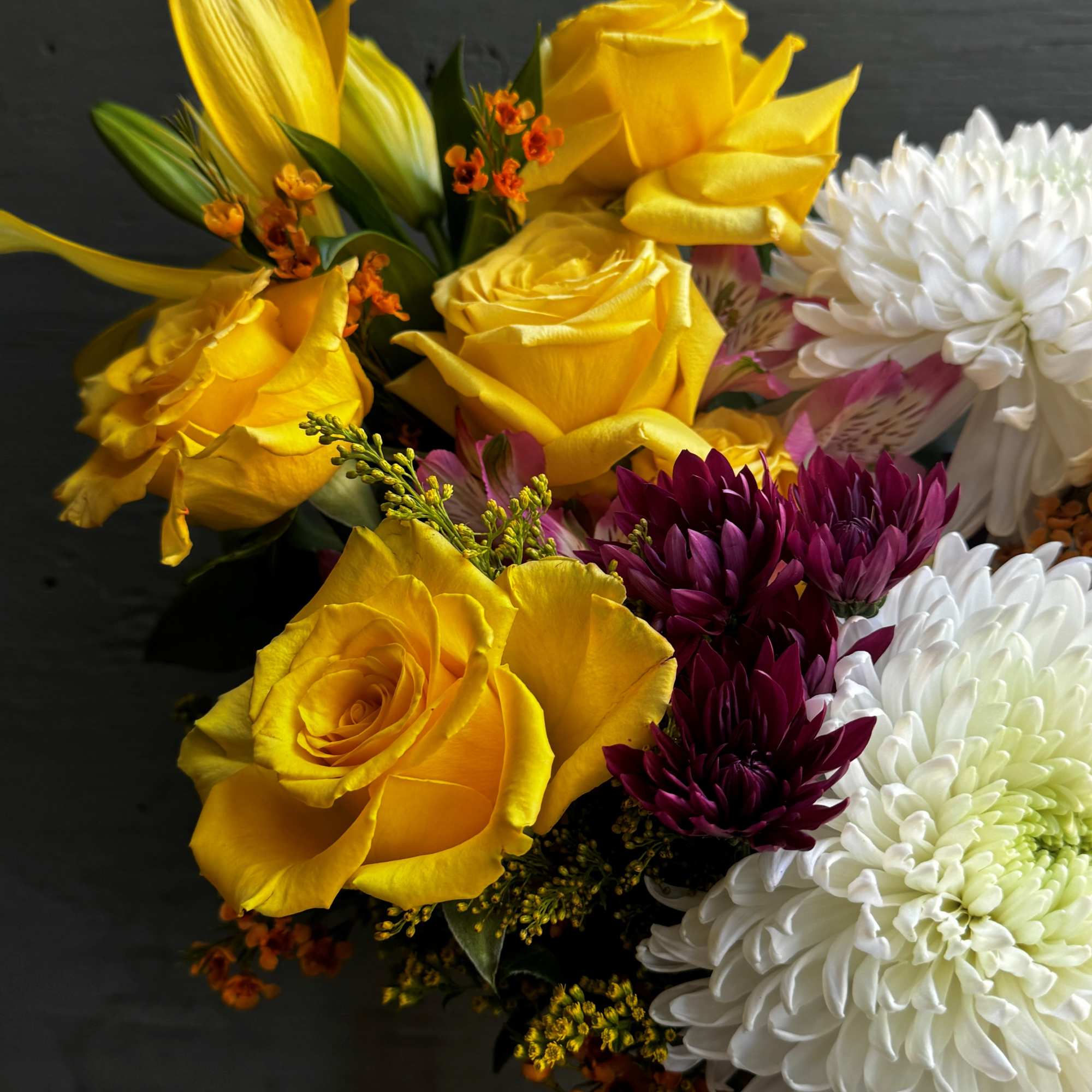 Bouquet of yellow roses and white chrysanthemums with purple blooms