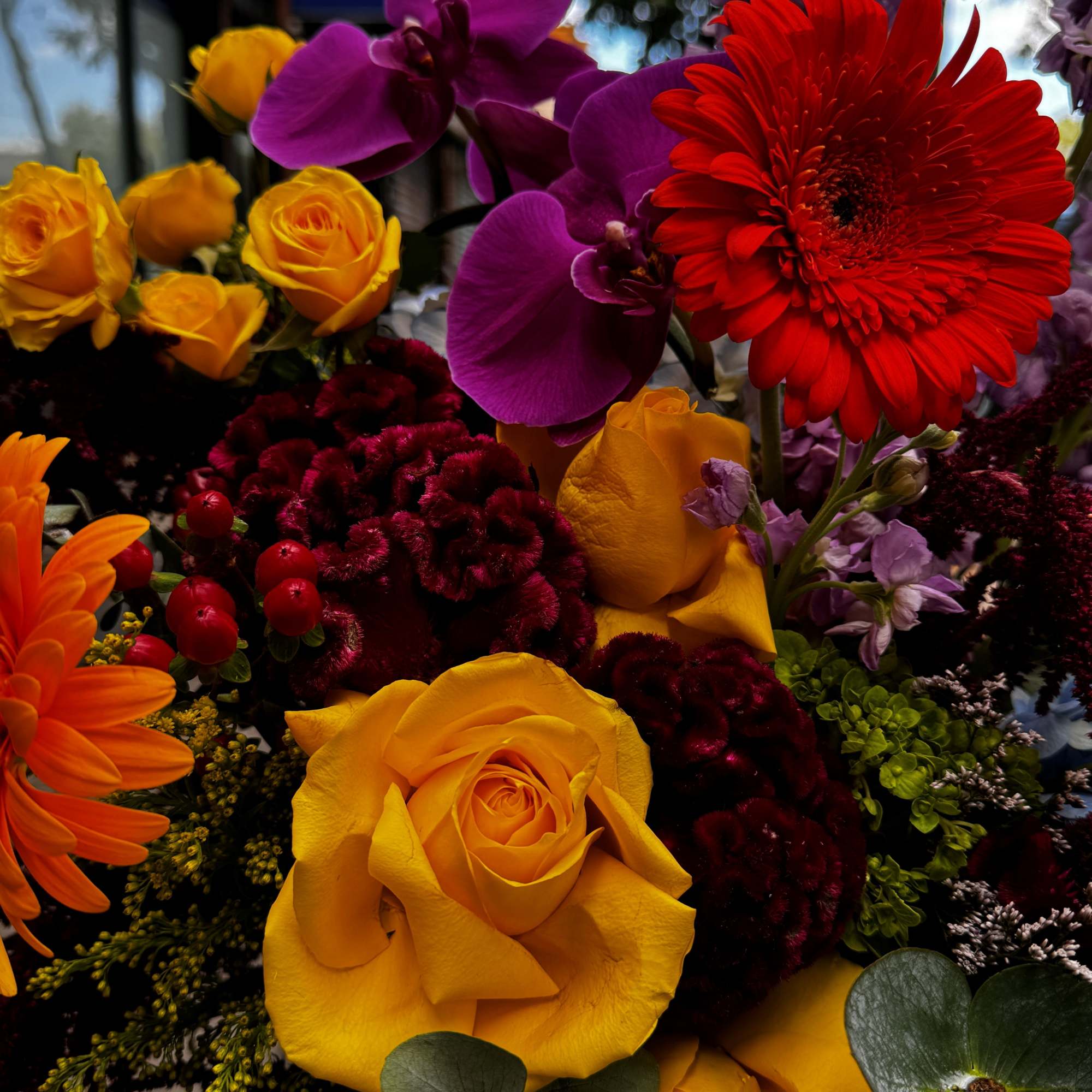 Bouquet of yellow roses, purple orchids, and red gerbera daisies