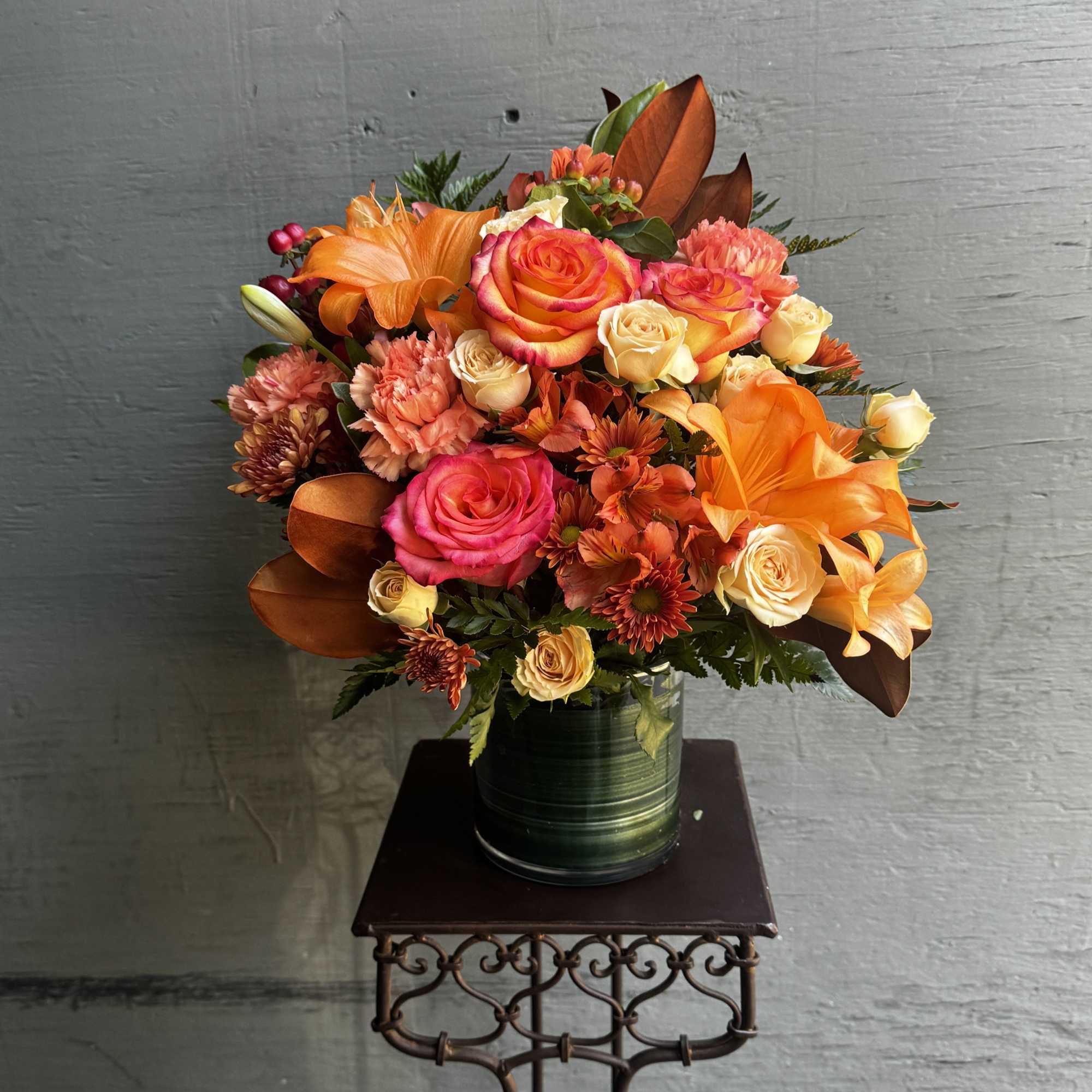 Bouquet of orange and pink roses in a green vase