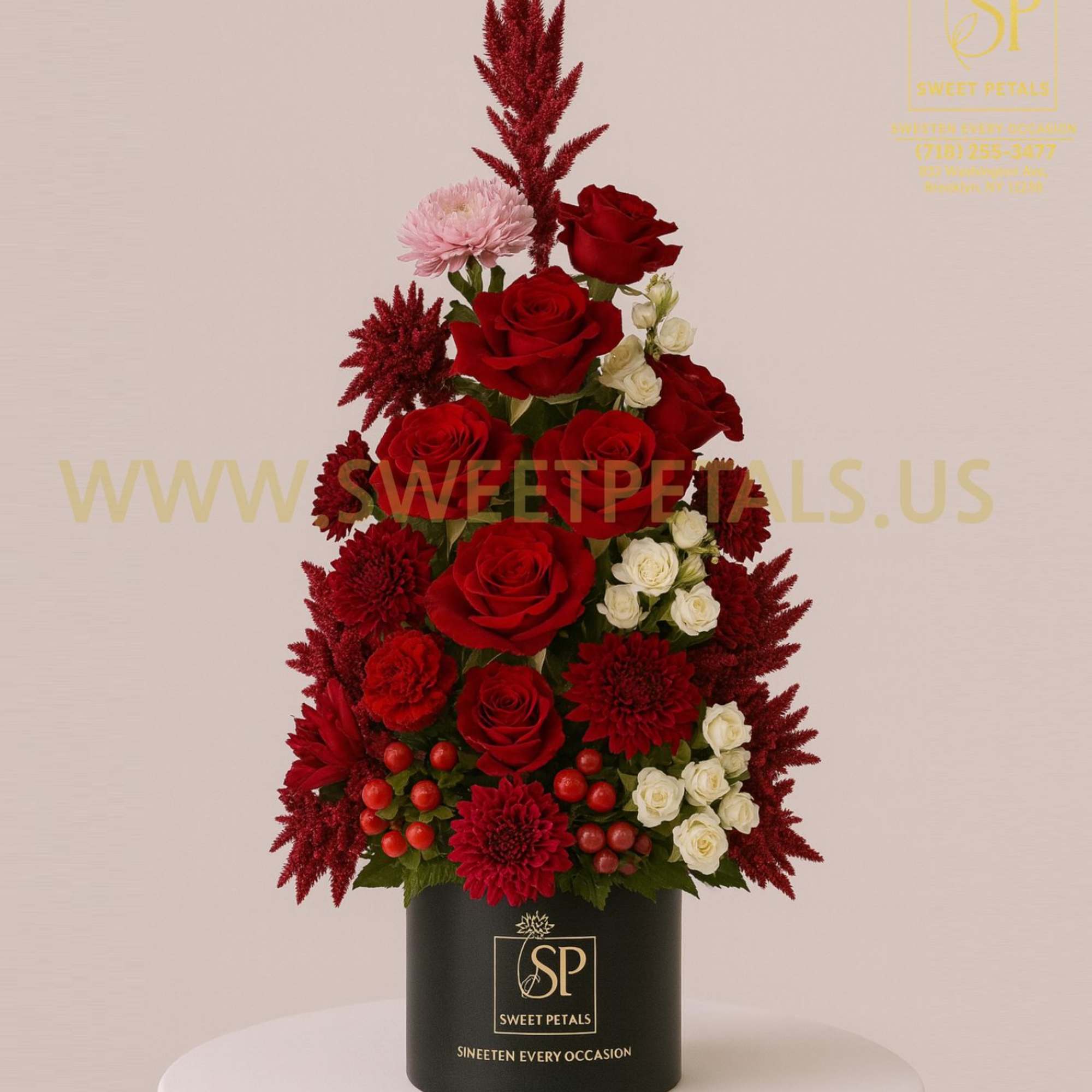 Red roses and white spray roses in a black hatbox
