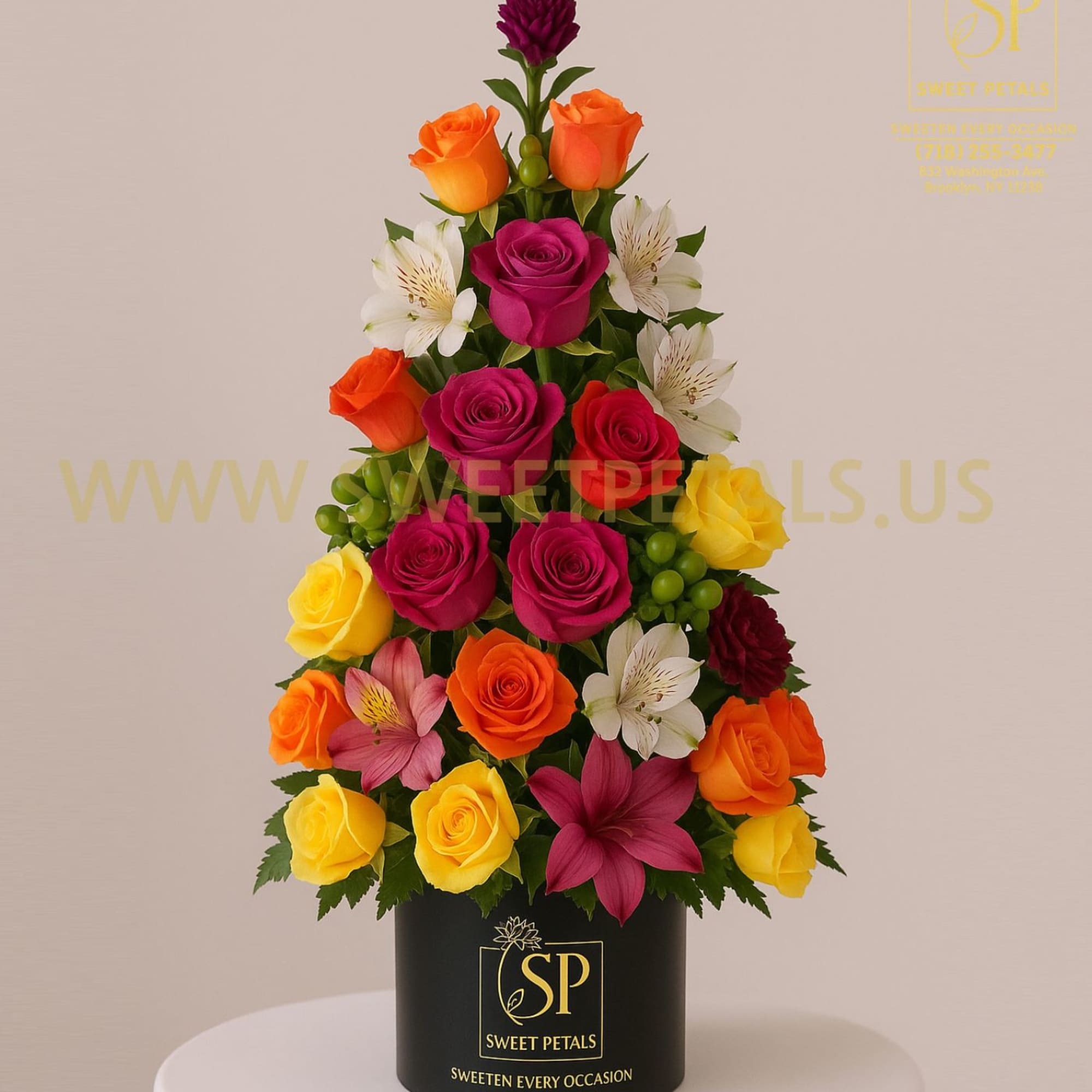 Cone-shaped arrangement of multicolored roses and lilies in a black box
