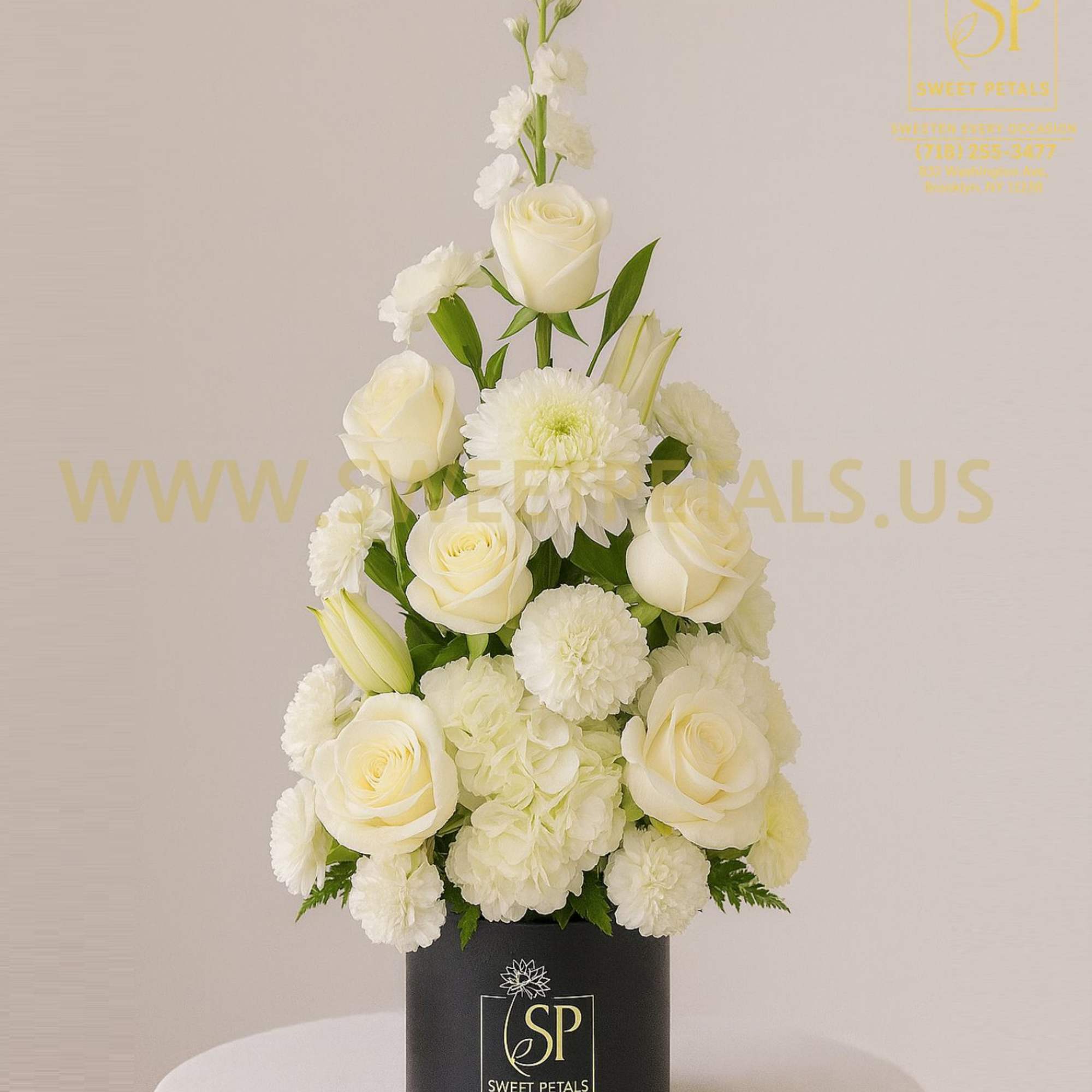 White roses and mums arranged in a black box vase