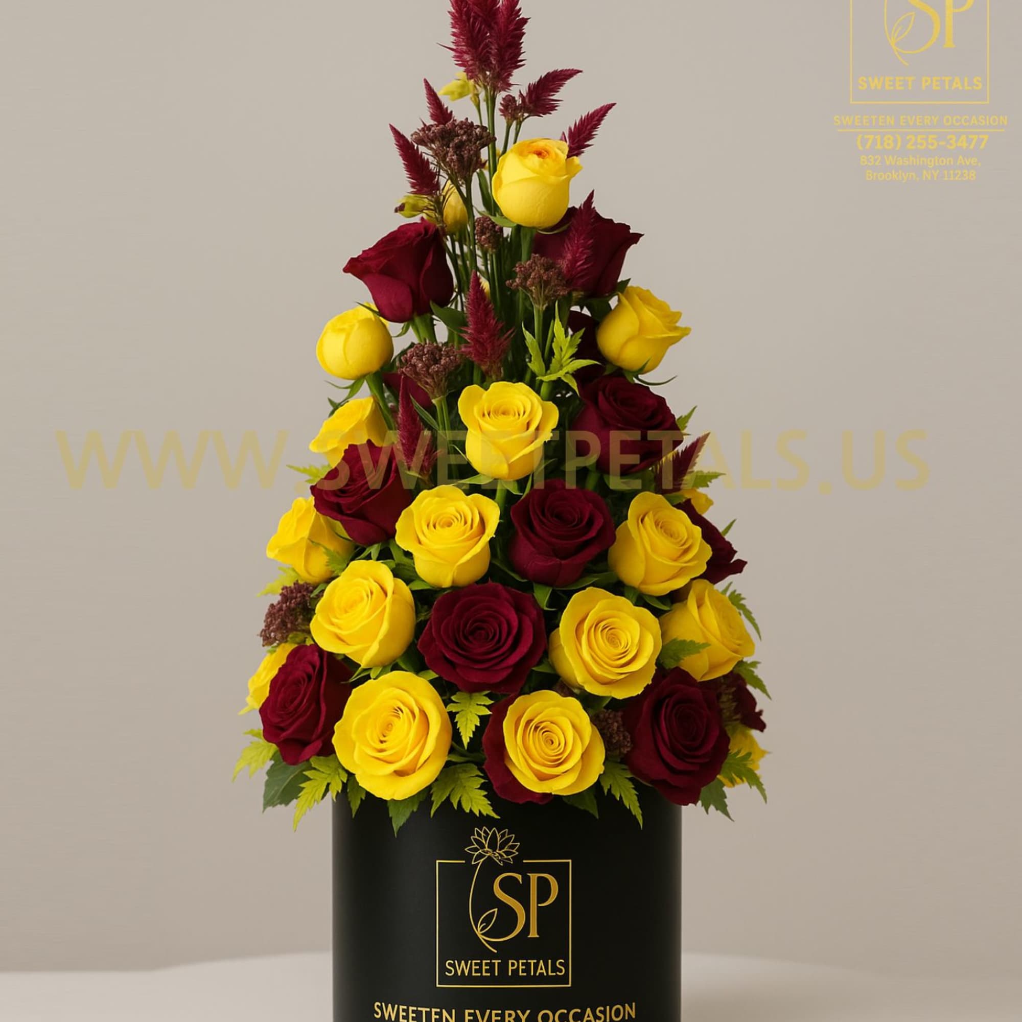 Tall arrangement of yellow and burgundy roses in a black box