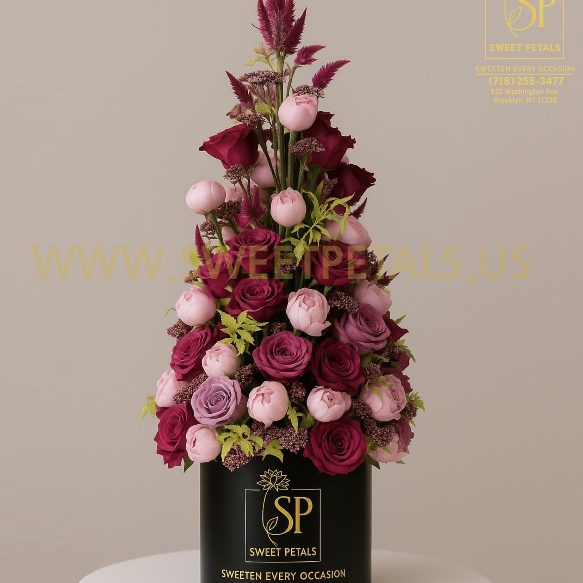 Tall arrangement of pink and burgundy roses in a black cylinder box