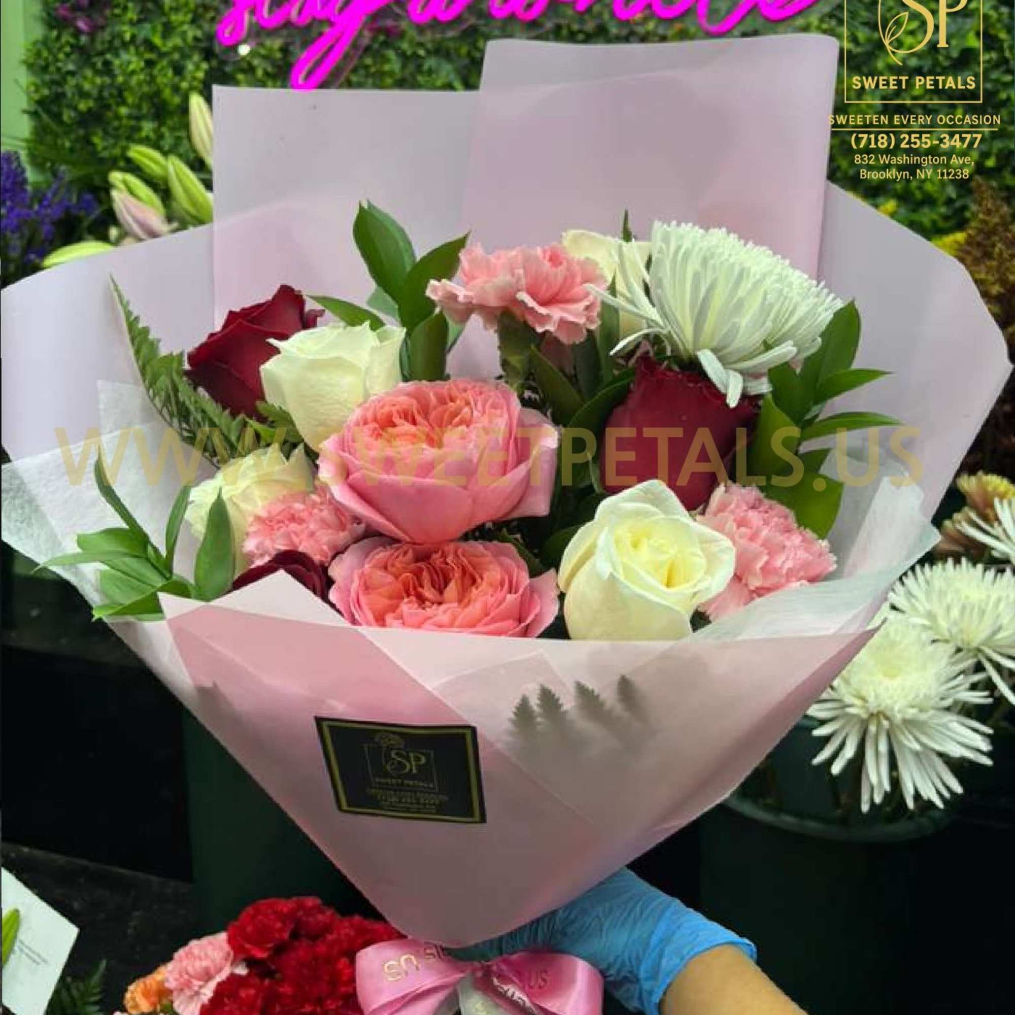 Pink and white bouquet of roses and carnations wrapped in pale paper
