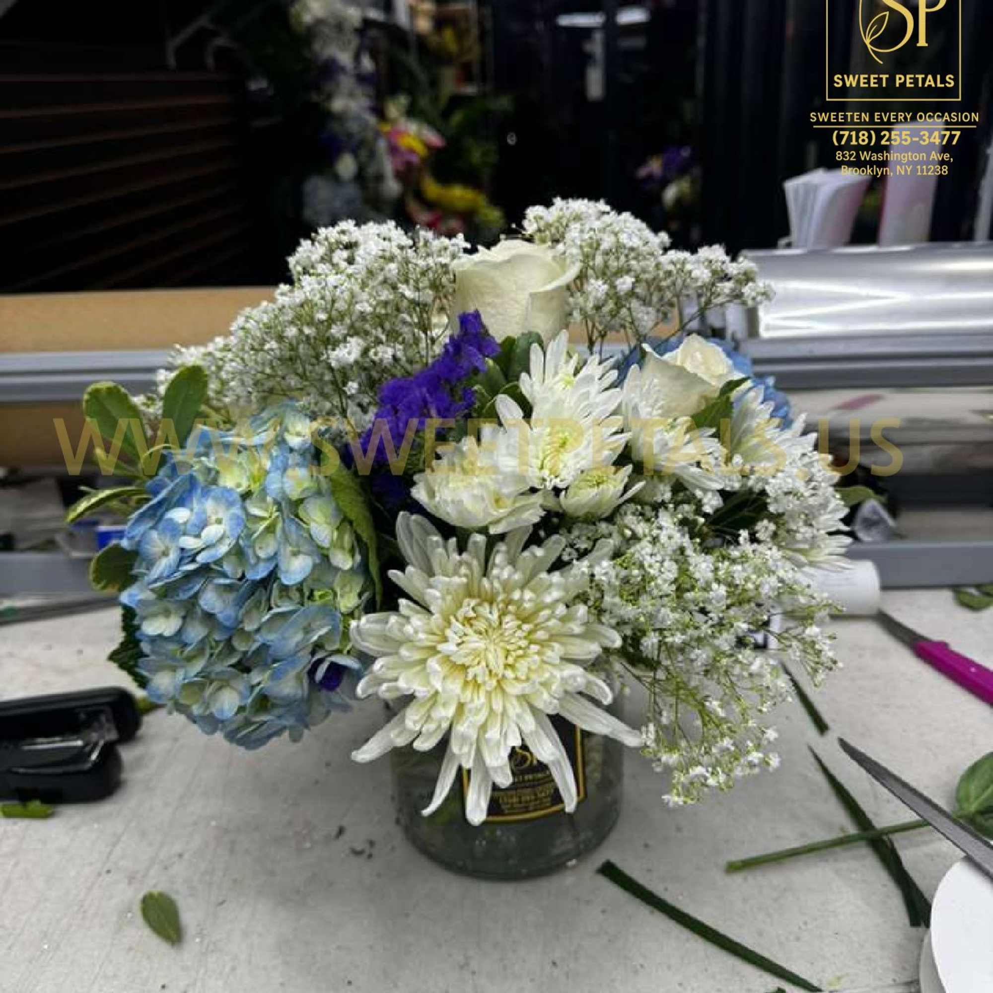 Bouquet of white and blue flowers in a small vase