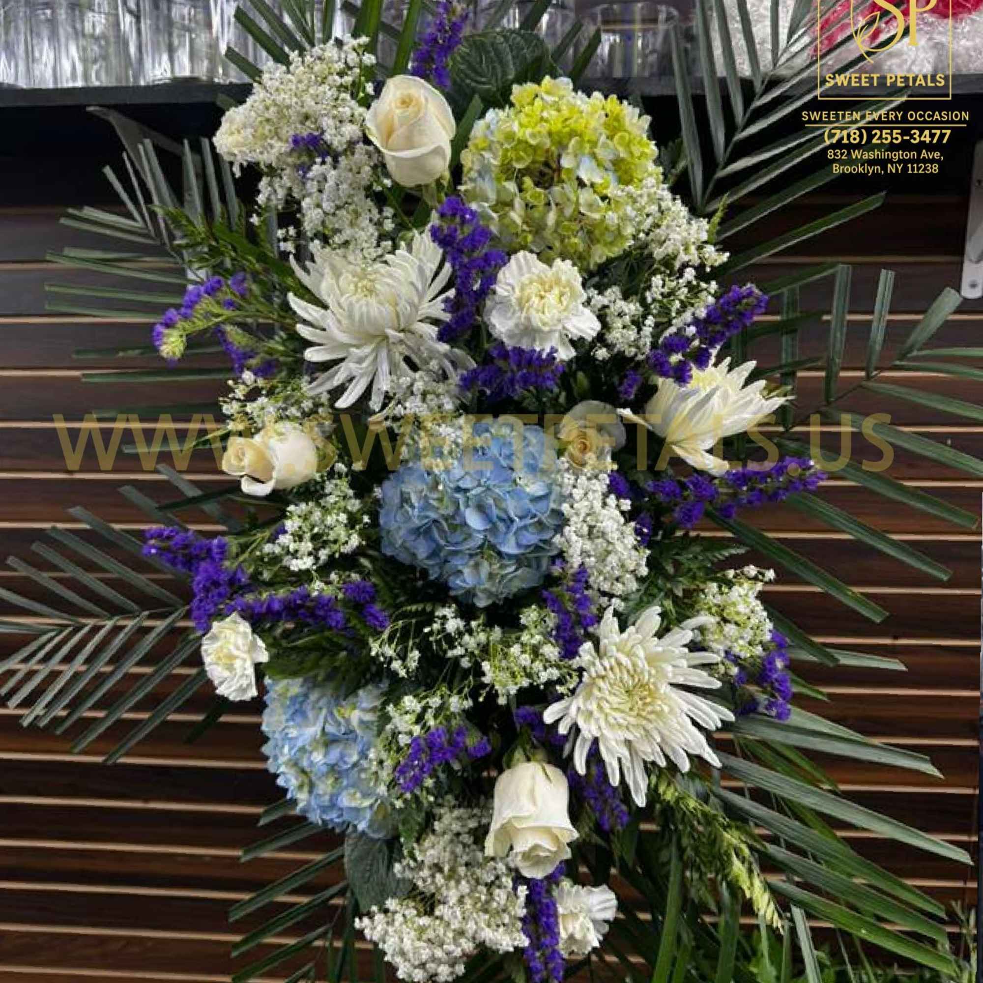 Standing floral spray with white, blue, and purple flowers