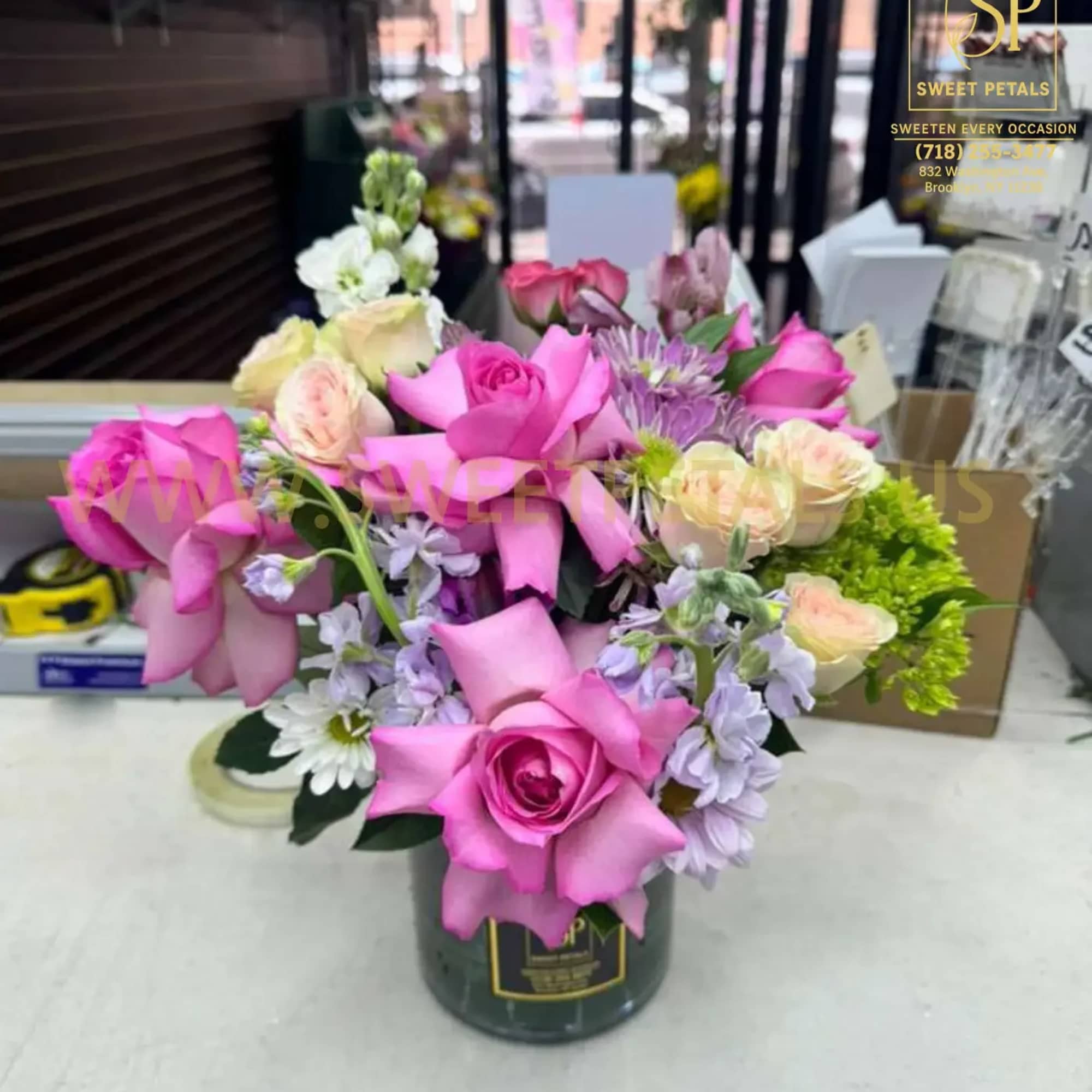 Pink and lavender rose bouquet in a dark vase