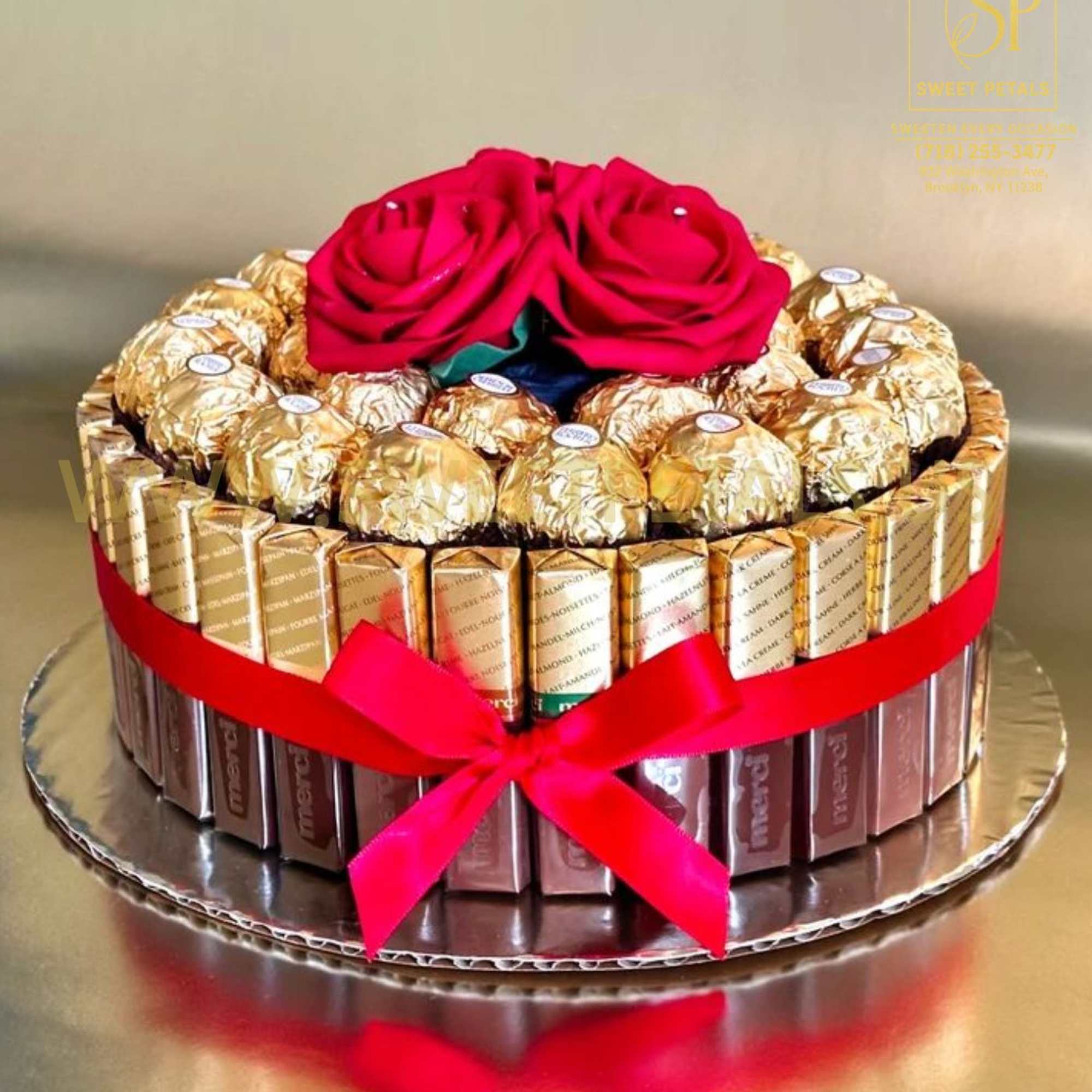 Chocolate gift box topped with two red roses and a ribbon