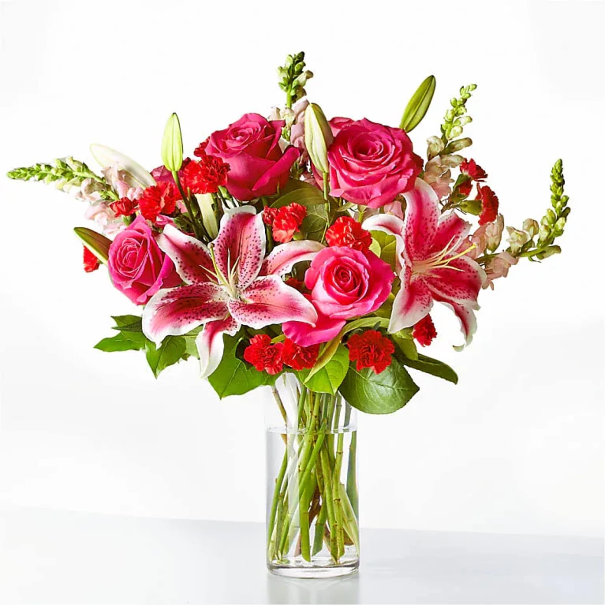 Pink roses and lilies arranged in a clear glass vase