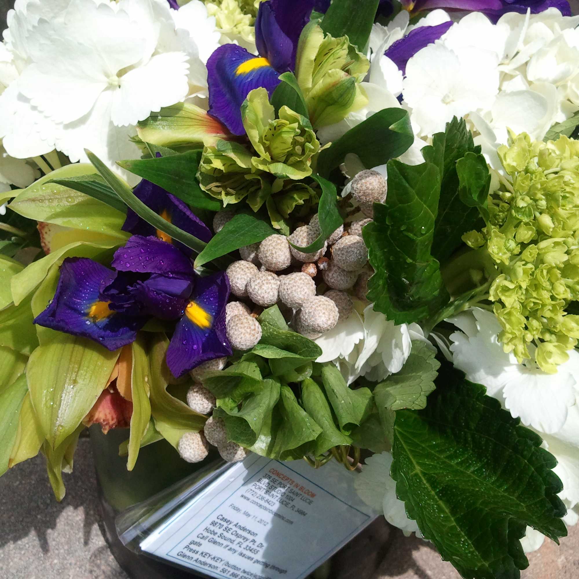 green cymbibium orchids, purple iris, bells of ireland, burmia berries, white and green cymbibium orchids, purple iris, bells of ireland, burmia berries, white and