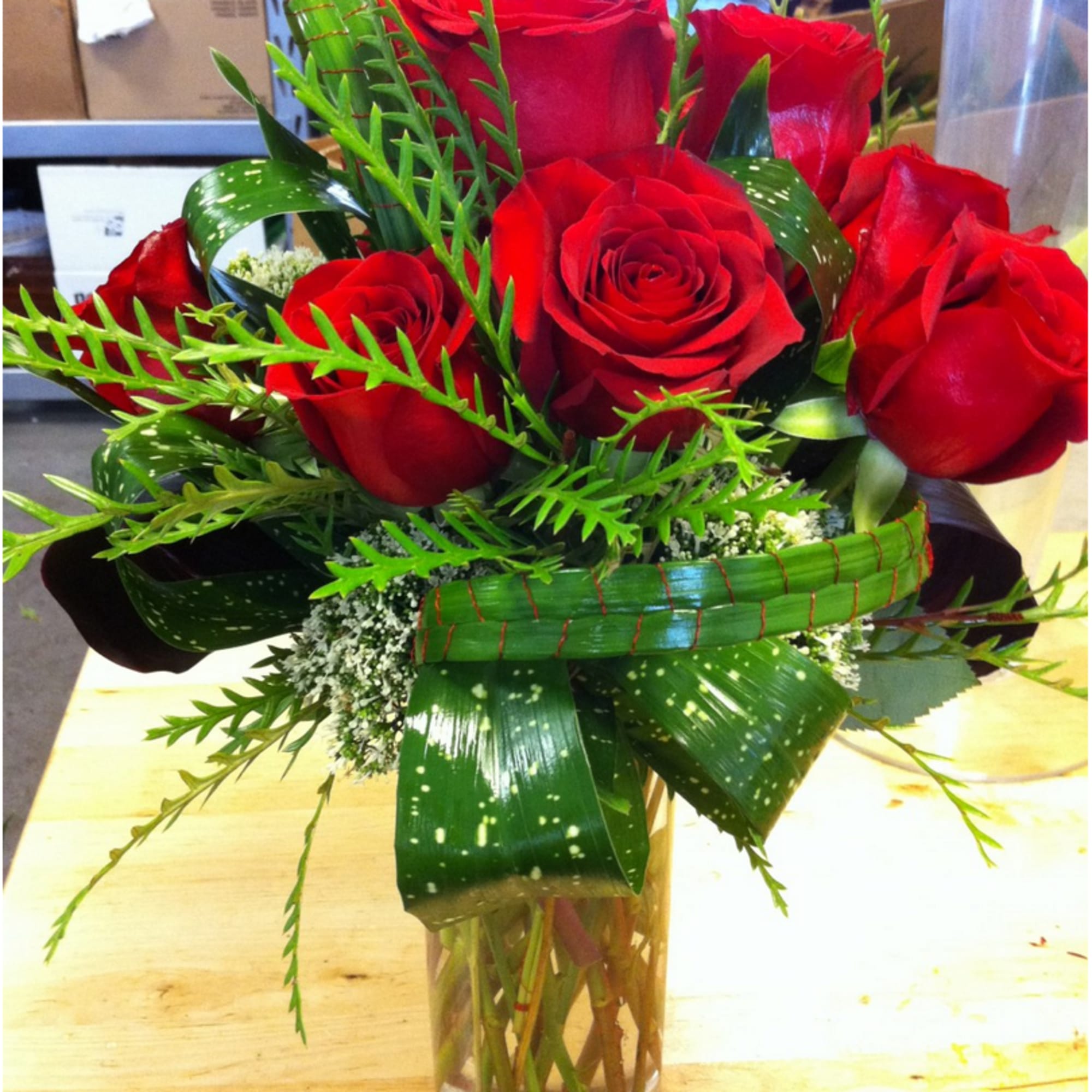 Red Roses with Accent Green in a vase.
