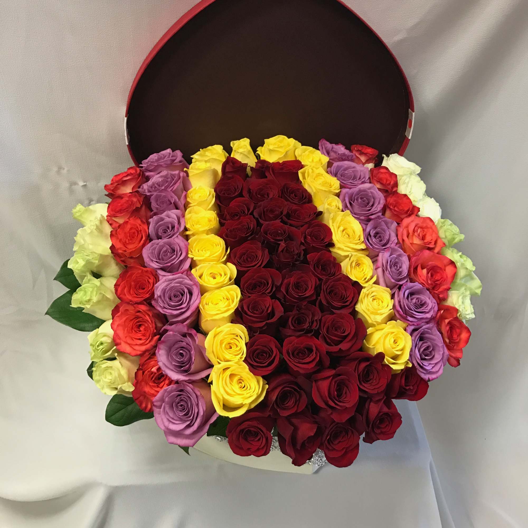 Beautiful mix color of roses inside of a heart shaped box. With