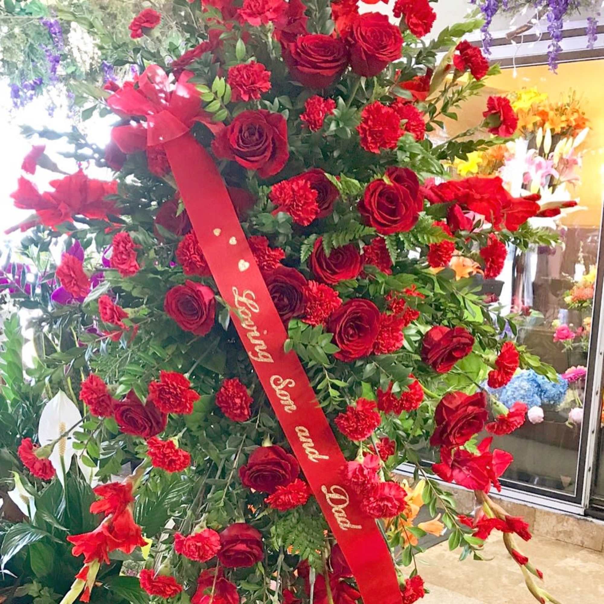 A grand tribute with red roses and carnations.