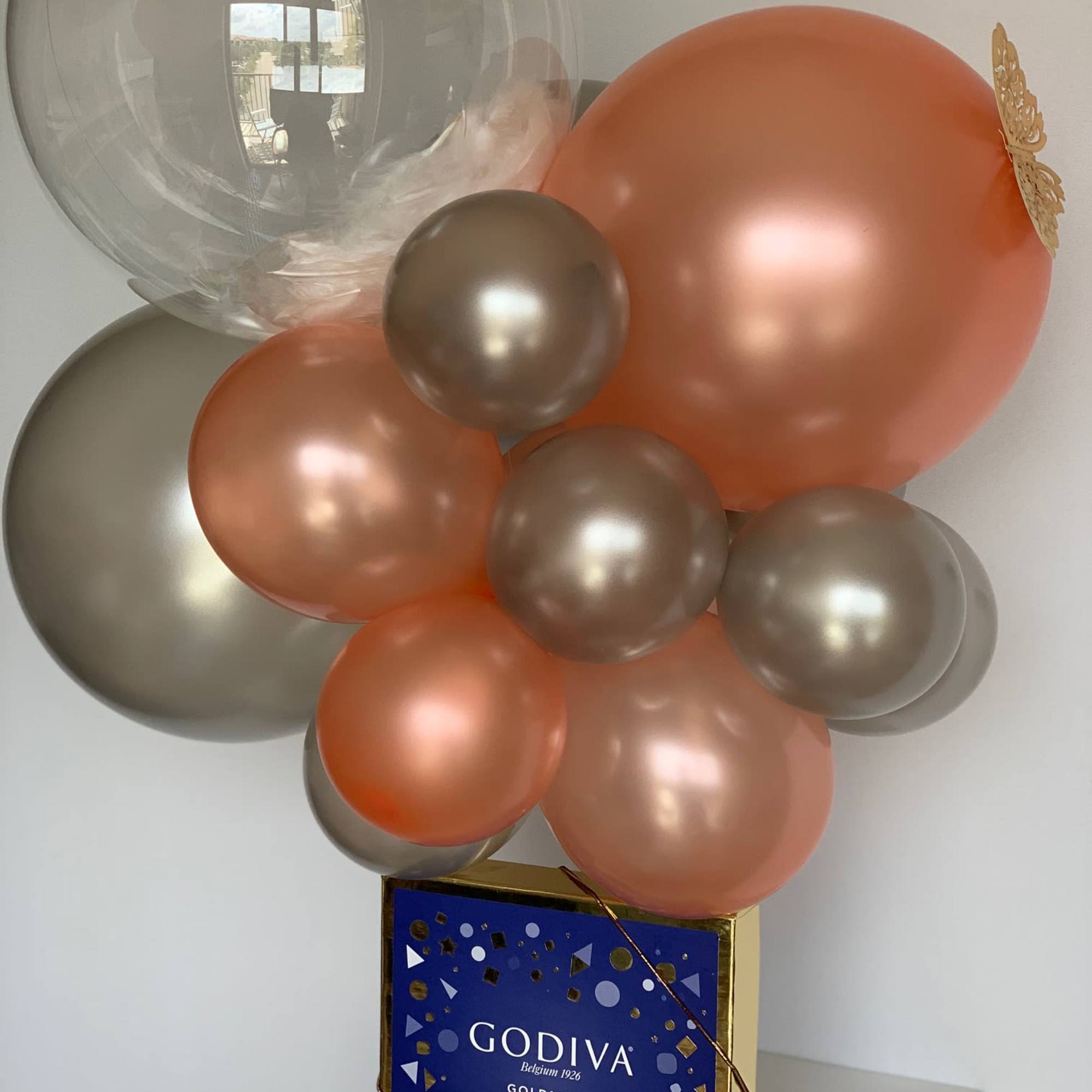 A Godiva chocolate gift box warped with the ribbon and crowned with