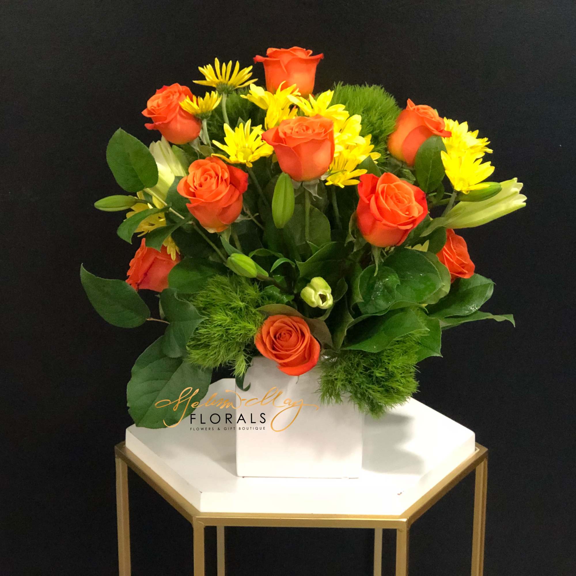 Bright-yellow lilies and fire-orange roses awaken the senses with sunny greetings for