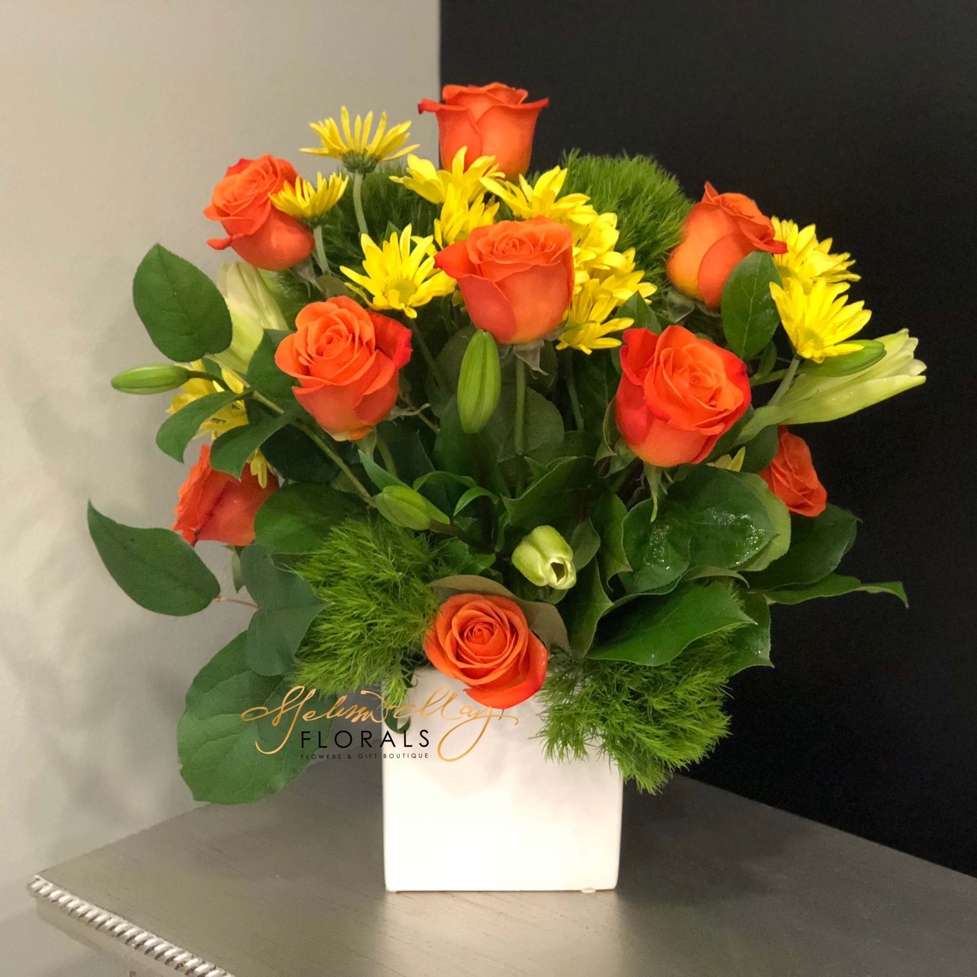 Bright-yellow lilies and fire-orange roses awaken the senses with sunny greetings for