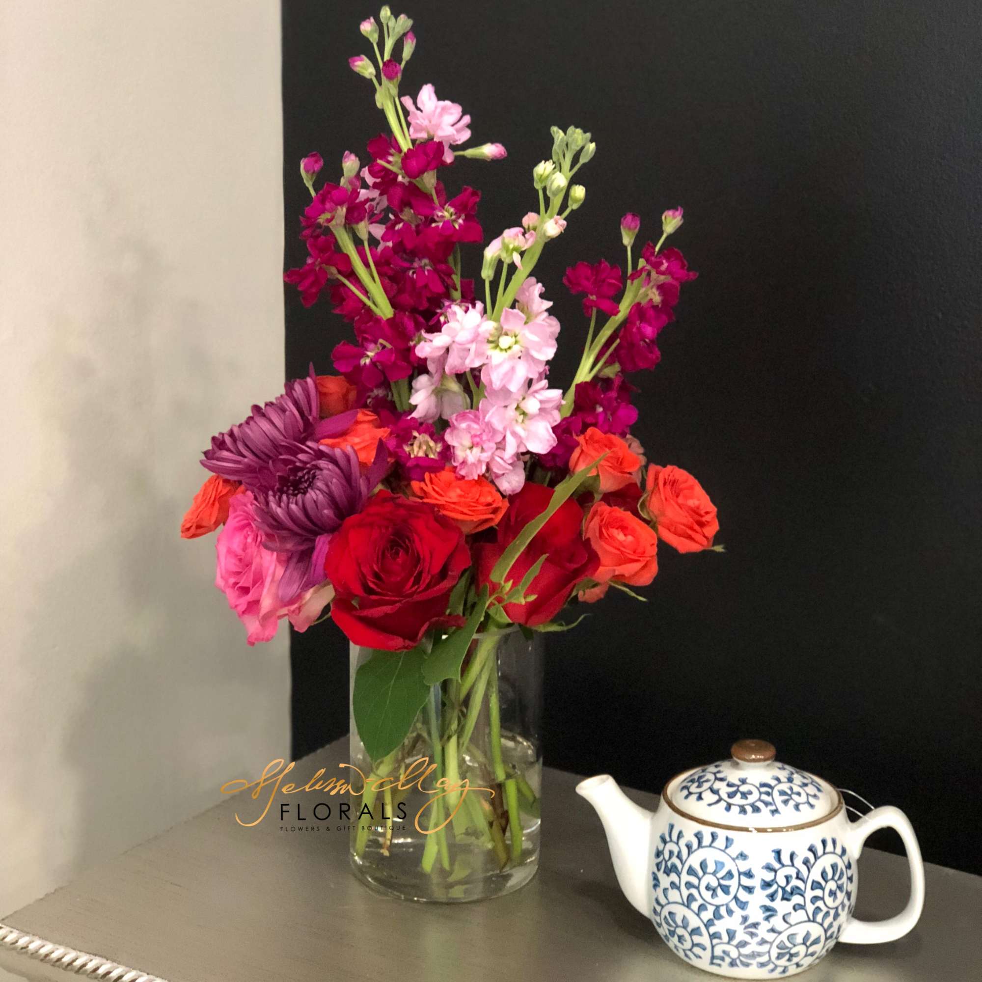 Here you see pink and purple stock stems, orange spray roses with