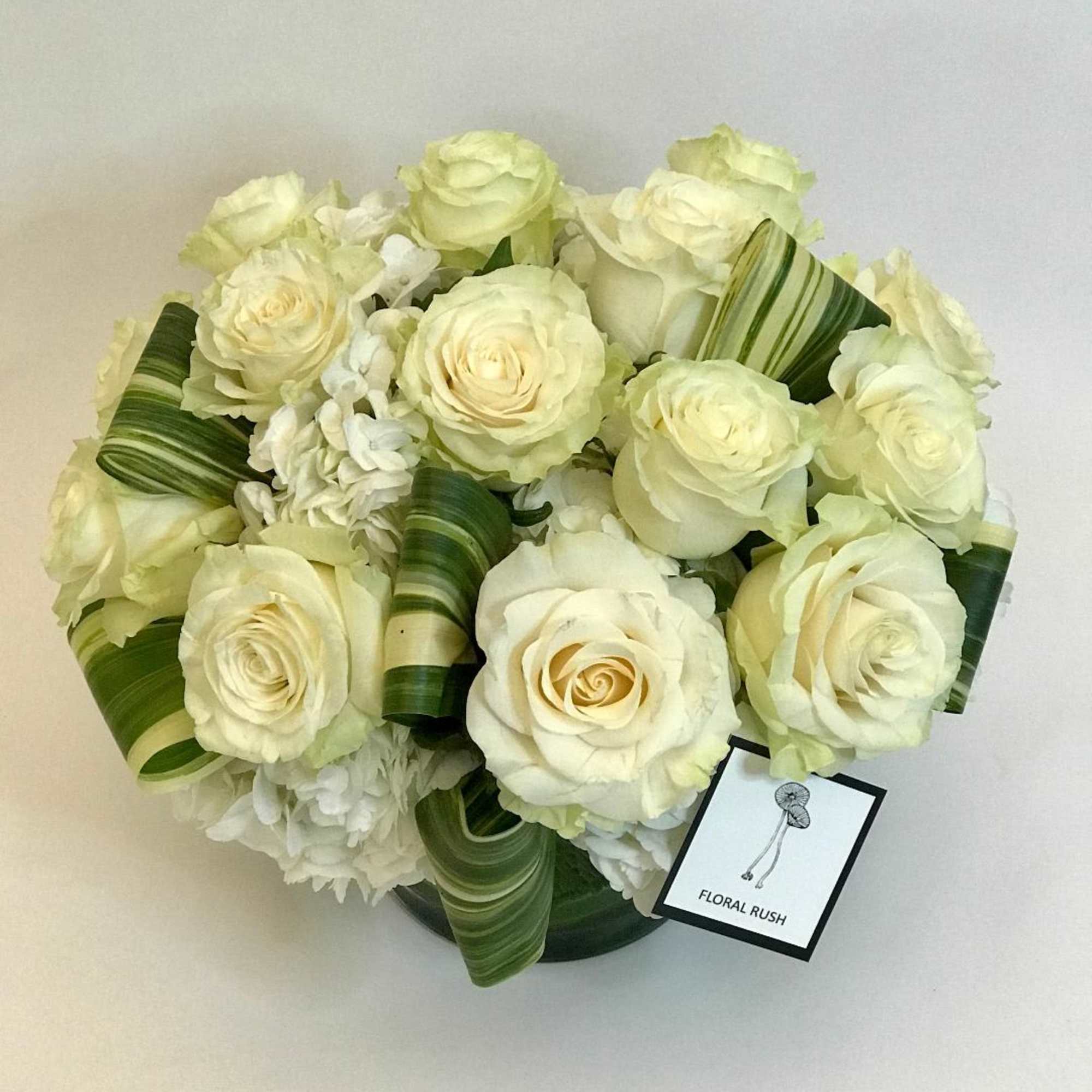 Exquisite white Mondial roses with hydrangea and aspidistra leaves